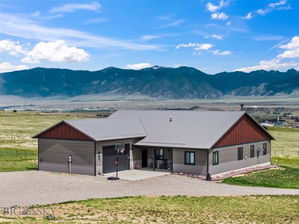 Rare opportunity to own 22 beautiful acres with NO COVENANTS in the heart of the Madison Valley, offering the freedom and flexibility that is increasingly hard to find in Southwest Montana. Conveniently located on Depot Road just minutes from Ennis and within an easy drive to Bozeman, this horse property combines privacy, functionality, and direct access to world-class recreation including fly fishing on the Madison River, hunting, hiking, horseback riding, and Yellowstone National Park adventures. Thoughtfully designed for comfortable living, this spacious 2,608 sq ft home features 4 bedrooms, 2.5 bathrooms, vaulted ceilings, and expansive Andersen windows that fill the home with natural light. One bedroom is currently being used as an office, offering excellent flexibility for remote work or additional living space. Extra-wide hallways, 9-foot ceilings, solid alder wood doors and trim, and custom blinds that raise or lower from either direction add quality and character throughout. The open living area is warm and inviting with a cozy wood stove, movie theater lighting accents, and stunning views of the surrounding property. The kitchen is designed for gathering and entertaining with rough-edge granite countertops, custom alder cabinetry, a large island, and an oversized walk-in pantry accessed through a beautiful barn door. Two spacious guest bedrooms feature large closets and share a well-appointed guest bathroom, while a large hall closet with additional barn doors provides abundant storage. The oversized primary suite offers a peaceful retreat with vaulted ceilings, an electric fireplace, sliding doors leading to the covered patio, and a luxurious ensuite bathroom complete with double vanities, a custom tile walk-in shower with dual shower heads, private toilet room, and a large walk-in closet with custom organizers. Additional features include a spacious laundry room located off the attached two-car garage, workout area, utility room, underground sprinklers, whole-house water filtration system with softener, and multiple heating options including wood heat, electric baseboard, and wall heaters. The expansive covered patio is wired for a hot tub and designed for enjoying Montana sunsets and wide-open views. The acreage is partially fenced with three separate pastures and is perfectly set up for horses with two shelters and two frost-free hydrants. This is Montana living with the freedom to truly make the property your own.
