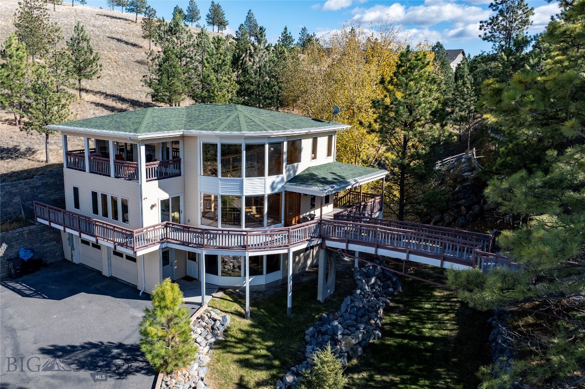 With striking architecture and light-filled spaces, this 4-bedroom, 4-bath home at the base of Nob Hill offers modern sophistication surrounded by mature trees and beautiful views. The grand entry showcases a floor-to-ceiling wall of windows and a dramatic staircase that sets the tone for the open, airy design. Multiple outdoor living areas create seamless indoor-outdoor flow—from the living room’s covered deck with dual-sided fireplace to the kitchen balcony and wraparound porch access from every bedroom. With clean, contemporary finishes, generous living spaces, an elevator, and a 3-car garage, this home is built for comfort, style, and connection to the outdoors.