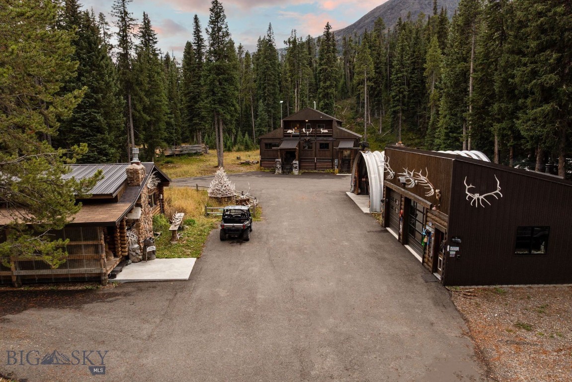 Welcome to Wildflower – Cooke City, a rare and versatile mountain retreat featuring two beautifully appointed dwellings on a breathtaking property bordering National Forest land with creek access. Perfectly situated just 7 miles from the Northeast Entrance of Yellowstone National Park, this one-of-a-kind offering provides unmatched access to some of the best snowmobiling, backcountry skiing, hiking, hunting, and fishing in the Rocky Mountains. The primary residence is a 1,800 sq ft, 3-bedroom, 3-bathroom home, originally built in 2000 and tastefully remodeled with a refined rustic charm that perfectly complements its alpine surroundings. Offered fully furnished, the home has been successfully operated as a short-term rental known as “Wildflower – Cooke City”, making it an excellent opportunity for both personal enjoyment and income potential. The second dwelling is a single-level, 1,148 sq ft log home featuring 3 bedrooms and 3 bathrooms. Warm, inviting, and authentically Montanan, this home offers additional living space for family, guests, or rental flexibility. Complementing the residences are exceptional outbuildings, including a 780 sq ft heated shop with two 10’x10’ overhead doors—perfect for vehicle or snowmobile storage—and a 900 sq ft Quonset metal building with a concrete foundation and power, ideal for equipment, gear, or hobby use. Whether you’re seeking a primary residence, investment property, or a mountain escape, this property delivers endless possibilities in a location that truly captures the spirit of Montana’s wild beauty—steps from the forest, minutes from Yellowstone, and surrounded by adventure in every direction.