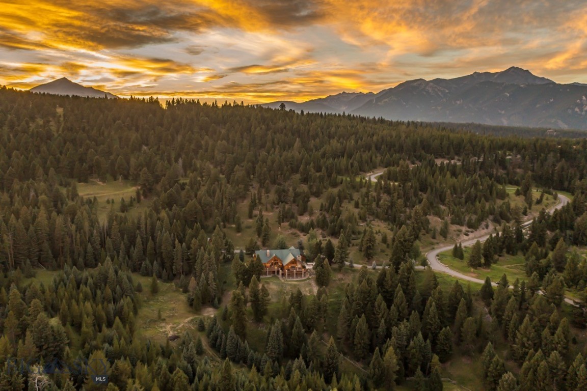 Nestled amidst the picturesque mountain landscape awaits an extraordinary retreat. This distinguished estate presents an exquisite main house spanning approximately 9,437 SF, and a 1,404 SF guest home. Crafted in 2002, this architectural marvel showcases 12" Swedish cope logs, floor-to-ceiling windows with 30' vaulted ceilings, and panoramic mountain vistas of Ramshorn Mountain and the Gallatin Range that inspire awe within every space. Stepping inside, you're greeted by a symphony of warmth and elegance, with six fireplaces adorning the expansive living spaces, including three authentic wood-burning hearths, inviting intimate gatherings and cozy evenings alike.

The gourmet kitchen, equipped with Viking, Thermador, and Bosch appliances, beckons culinary enthusiasts with its Sub-Zero wine cooler and granite countertops, while smart home technology seamlessly integrates Lutron and Crestron systems, offering ultimate control over lighting, security, and sprinklers. Year-round comfort is assured with in-floor radiant heating, a sauna, and gym area, while the outdoor kitchen and dining area provide an idyllic setting for al fresco entertaining against the backdrop of Montana's beauty. For added peace of mind, the estate boasts a backup generator, security systems, and a sprinkler system, ensuring security and tranquility in equal measure.

Beyond the main residence lies a charming 1,404-square-foot guest house, built in 2010, featuring one bedroom + bonus room, one bathroom, kitchen, living room, and a spacious three-car garage with extended doors, catering to horse trailers, RVs, and more. Spread across 20 acres, the estate includes eight acres of cross-fenced land, perfect for equestrian pursuits, along with a two-stall shed and a round pen, providing ample space for cherished equine companions. Conveniently located within the prestigious Big Sky school district and a short drive from all that broader Big Sky provides- the Big Sky town center, the coveted Gallatin River, Yellowstone National Park, and the world-class skiing at Big Sky Resort are all just a short drive away. Bozeman and West Yellowstone are also just an hour away for residents to enjoy even greater access to outdoor recreation, cultural attractions, and everyday conveniences. 

Whether you seek a serene retreat or an entertainer's paradise, this distinguished estate promises an unparalleled opportunity to embrace with comfort the timeless allure of Montana's majestic landscape.