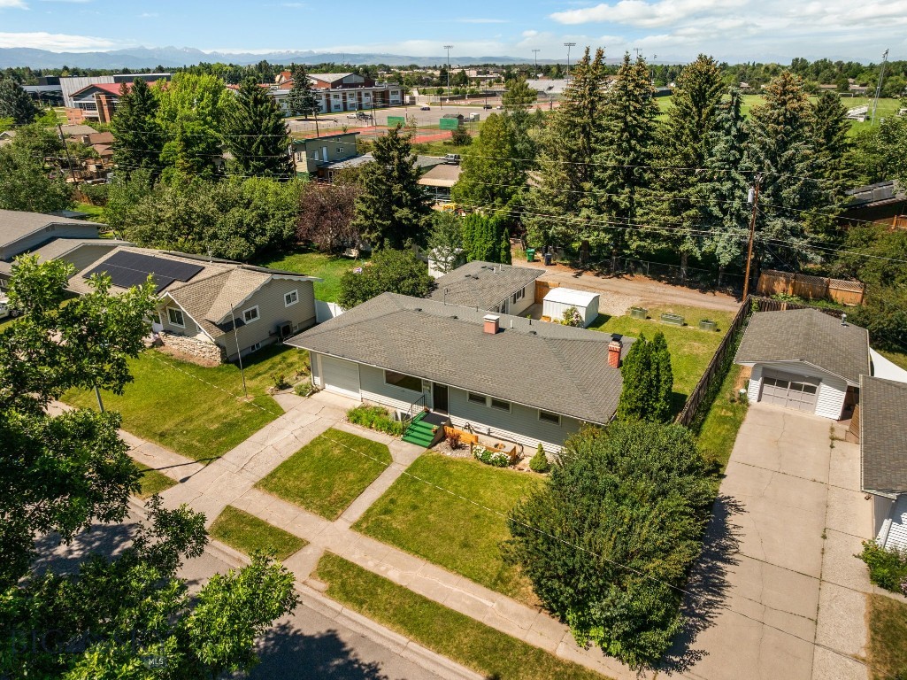 Enjoy the best of central Bozeman living at 439 N. 10th Avenue, ideally located on a quiet, low-traffic street just blocks from Midtown, Downtown, Bozeman High School, Montana State University, neighborhood parks, restaurants, and shopping. Thoughtfully updated and meticulously maintained, this unique property pairs a beautifully renovated main home with a detached guest cottage/accessory dwelling unit (ADU), offering exceptional flexibility for a variety of lifestyles. The 4-bedroom, 2-bath main home features beautifully refinished oak hardwood floors, a remodeled kitchen with custom cabinetry, butcher block countertops, black-and-white marble tile, newer appliances, and a finished lower level with a spacious family room, wood-burning fireplace, full bath, generous laundry and storage room, and an additional bedroom with a full-size egress window. The detached, alley-accessed ADU offers nearly 450± square feet with a kitchenette, 3/4 bath, walk-in closet, washer and dryer, on-demand hot water, free-standing gas stove, and mini-split heating and cooling. Whether used for guests, multigenerational living, a private home office, or as a property with a proven rental history, it provides flexibility that is increasingly difficult to find in central Bozeman (buyers to verify permitted uses). Outside, enjoy a backyard designed for relaxing and entertaining with a spacious patio, café string lights, raised garden beds, established landscaping, and a heated garage. Rare alley access provides abundant off-street parking for multiple vehicles, trailers, and all your Montana gear. Combining an unbeatable in-town location, thoughtful updates, flexible living spaces, and a detached guest cottage with proven rental history, 439 N. 10th Avenue is a rare opportunity to own a property that adapts to the way you live today while offering possibilities for tomorrow.
