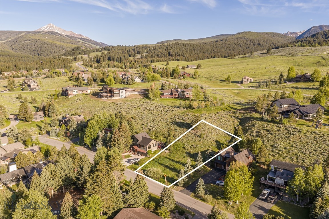 Wake up each morning to Montana sunrises and end each day beneath the glow of alpenglow from this beautifully situated homesite on Little Coyote Road. Nestled on the uphill side of the road in an established Big Sky neighborhood, Lot 20 offers approximately a quarter acre of mature trees, native vegetation, and a natural wildflower meadow that changes with the seasons.

The gently rising terrain creates an ideal setting for a home with a walkout lower level, while the southeastern orientation invites abundant sunshine throughout the day. Enjoy the peaceful setting, minimal HOA dues, and the freedom of no required timeframe to build. Whether your vision is immediate or years in the making, this is a rare opportunity to secure a homesite where natural beauty and flexibility come together in the heart of Big Sky.