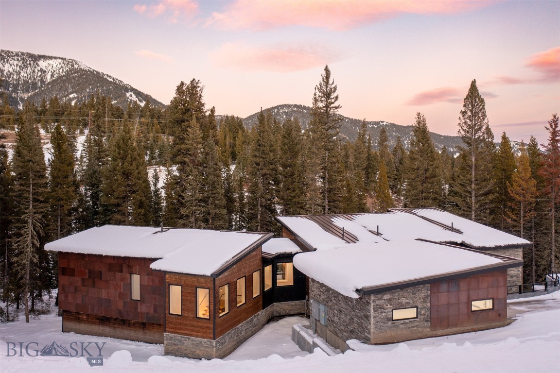 Now offered at $2,999,000, this contemporary mountain home presents one of the most compelling values in Big Sky. Completed in 2024 and never occupied, the residence offers a rare opportunity to own a brand-new custom home without the time, uncertainty, or expense of building. The landscaping is complete, and the home is being offered as-is, ready for its first owner to make it their own.

Situated in the Antler Ridge neighborhood, midway between Big Sky Resort and Meadow Village, this 4,863-square-foot residence is positioned among mature trees and backs directly to Antler Ridge open space, creating a private and peaceful mountain setting. The Big Sky Trail System runs through the neighborhood, providing easy access to hiking, biking, and cross-country skiing right from your doorstep.

Designed to maximize space and functionality in mind, the home features three expansive primary suites, two additional bedrooms, multiple living areas, and a main-level powder room. Two laundry rooms—one on each level—and a secondary kitchen area in the walk-out lower level make the home exceptionally well-suited for large families, entertaining, or hosting guests.

The home showcases steel beam construction, Richlite, Kebony, and Cor-Ten steel siding, tigerwood decking, and a cold metal roof. The chef's kitchen is equipped with Viking appliances, while Warmboard radiant floor heating, smart thermostats, smart mirrors, smart toilets, and a whole-home Sonos sound system provide modern comfort and convenience.

With a new price of $2,999,000, this never-lived-in contemporary residence offers an exceptional opportunity to own a beautiful home in one of Big Sky's most convenient neighborhoods.