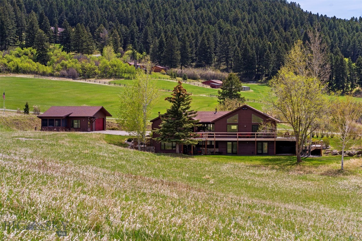Situated in the heart of prestigious Bridger Canyon, this stunning home sits on nearly 26 acres just ~6 miles from Bozeman.  Offering some of the most striking views in the area, the property captures the best of Montana living—sweeping Bridger Range vistas, abundant wildlife, and access to world-class recreation including Bridger Bowl Ski Area, hiking trails, and Gallatin National Forest.

The private setting is conveniently close to town, ideal for those seeking a rural lifestyle with modern convenience. Bridger Bowl is ~11 miles up the canyon and the “M” Hiking Trail is just ~4 miles toward town. 

Built in 1992 with expansion in 2002, the home is designed for comfortable daily living. A dramatic wall of windows in the great room flood the interior with natural light and frame the ever-present scenery. Every bedroom opens directly to the outdoors through exterior doors, creating a seamless indoor-outdoor connection that defines the property’s appeal.

A two-level deck (new 3 years ago), porch, and patio provide choices for morning coffee, evening relaxation, or entertaining while soaking in the scenery.

The landscaped yard features a rock-bordered gathering area—ideal for a fire pit. Two garages and a generous parking area offer space for guests, campers, boats, or other toys.

The living room features a gas fireplace framed by built-in cabinetry, while the adjacent dining area sits beside the expansive windows. The kitchen is a gourmet hub with a high-end Frigidaire Gallery range & refrigerator, wine fridge, and pantry. A custom bar top was crafted from a plank salvaged from a sunken Lake Michigan steamboat adding historic flair. 

The primary bedroom has vaulted ceilings, large windows, and a door to a seating area on the deck—perfect for mountain gazing. The primary bathroom features a tiled shower, dual vanities, plus an additional vanity nook.

A basement family room and den provide areas for relaxation with two sets of stairs (one at each end of the home)—including a striking spiral staircases. 

The detached garage features a heated studio space, perfect for painting, woodworking, fly-tying, ski tuning, or other hobbies, opening into a screened-in sunroom.

Perfectly suited to the Bridger Canyon lifestyle, the design celebrates the outdoors—whether inside or out. The combination of thoughtful features, generous storage, and unmatched natural beauty makes this property a rare find in one of Bozeman’s most desirable areas.