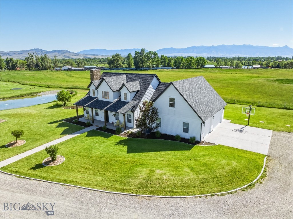 Here's a fabulous opportunity to own a large, gorgeous home on acreage, close to Manhattan!  Boasting over 3300 SF, this home has hardwood floors, central AC, a large living room with a gas fireplace, a main floor primary suite, dedicated dining room, laundry room, half bath, and a kitchen with beautiful Bridger Mountain views, concrete countertops, and an island.  Two separate stairways lead to the spacious upstairs level, where you will find two more large bedrooms, a full bathroom, office area, and a huge bonus room with a half bath!  Great for a 4th bedroom, rec room, family room -- you name it!  The 3-car garage has some separation so you can heat part if you desire, and one area has finished walls as it is currently set up as a game room!  Currently being divided into two lots, this home will sit on approximately 2 acres and is set up with a garden spot, a greenhouse (with watering system), and a cute shed that could be a playhouse or storage area. Farm animals allowed on this parcel, making it the perfect hobby farm opportunity! Underground sprinklers, underground dog fencing, and a new roof (in 2025) are added bonuses! The subdivision fire control pond sits on this property, giving you that water feature that so many people desire.  And did we mention the views??  The unobstructed views of the Bridgers from the back patio are phenomenal, and you can also see the Gallatins, Spanish Peaks, and Tobacco Roots! Take the paved trail to the Gallatin River for great fishing, or to downtown Manhattan for shopping and dining! And another bonus:  this home can be sold furnished (with just a few exceptions)!
