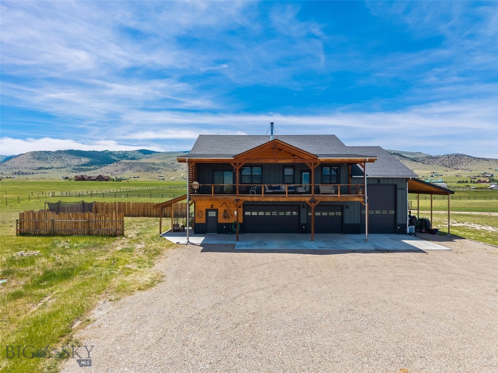 Experience Montana living at its finest on this exceptional horse property in Shining Mountains, featuring two residences, expansive garage space, and breathtaking views of the Madison Range. Located just minutes from Ennis, this property offers privacy, functionality, and easy access to world-class recreation. The 3,380 sq. ft. main home features 2,200 sq. ft. of living space on the upper level with vaulted ceilings, abundant natural light, and an open floor plan designed to capture the mountain views. The spacious living area includes a wood-burning stove and office nook. The chef's kitchen offers granite countertops, custom tile backsplash, decorative tin accent behind the stove, farmhouse sink, large oak-topped island with secondary sink, abundant cabinetry, and a 5-burner gas range and hood. A barn door leads to a large pantry with its own sink. The primary suite features deck access, a large walk-in closet, and a luxurious bath with soaking tub, tiled walk-in shower, double vanity with quartz countertops, and private water closet. Two generously sized guest bedrooms share a full bath with double vanity and tiled tub/shower surround. A large laundry room includes cabinetry and utility sink. Additional amenities include forced-air propane heat, a 1,000-gallon propane tank, on-demand water heater, water softener, and water filtration system. Enjoy spectacular Madison Range views from the expansive covered deck that spans the living area. The 1,180 sq. ft. lower level includes a three-car garage, heated RV garage, full bathroom, gym with windows, utility room, large storage room, and a versatile bonus room with closet. The separate 831 sq. ft. guest home offers 1 bedroom, 1 bath, attached two-car garage, tiled entry, LVP flooring, wood stove, propane wall heater, kitchen with pantry, laundry area, water softener, and a spacious bath with double vanity and ample storage. Equestrian improvements include fenced pasture, watering post, seasonal irrigation ditch, tack room with upper storage, hay storage, and loafing shed. Outdoor enthusiasts will appreciate the property's proximity to the Madison River, Blue Ribbon trout fishing, hunting, hiking, horseback riding, boating, camping, skiing, and thousands of acres of public land. Enjoy the shops, dining, and year-round events of Ennis while embracing the beauty and freedom of Montana living. A rare opportunity to own a versatile mountain-view property with room for horses, guests, hobbies, and adventure.