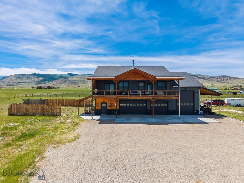 Experience Montana living at its finest on this exceptional horse property in Shining Mountains, featuring two residences, expansive garage space, and breathtaking views of the Madison Range. Located just minutes from Ennis, this property offers privacy, functionality, and easy access to world-class recreation. The 3,380 sq. ft. main home features 2,200 sq. ft. of living space on the upper level with vaulted ceilings, abundant natural light, and an open floor plan designed to capture the mountain views. The spacious living area includes a wood-burning stove and office nook. The chef's kitchen offers granite countertops, custom tile backsplash, decorative tin accent behind the stove, farmhouse sink, large oak-topped island with secondary sink, abundant cabinetry, and a 5-burner gas range and hood. A barn door leads to a large pantry with its own sink. The primary suite features deck access, a large walk-in closet, and a luxurious bath with soaking tub, tiled walk-in shower, double vanity with quartz countertops, and private water closet. Two generously sized guest bedrooms share a full bath with double vanity and tiled tub/shower surround. A large laundry room includes cabinetry and utility sink. Additional amenities include forced-air propane heat, a 1,000-gallon propane tank, on-demand water heater, water softener, and water filtration system. Enjoy spectacular Madison Range views from the expansive covered deck that spans the living area. The 1,180 sq. ft. lower level includes a three-car garage, heated RV garage, full bathroom, gym with windows, utility room, large storage room, and a versatile bonus room with closet. The separate 831 sq. ft. guest home offers 1 bedroom, 1 bath, attached two-car garage, tiled entry, LVP flooring, wood stove, propane wall heater, kitchen with pantry, laundry area, water softener, and a spacious bath with double vanity and ample storage. Equestrian improvements include fenced pasture, watering post, seasonal irrigation ditch, tack room with upper storage, hay storage, and loafing shed. Outdoor enthusiasts will appreciate the property's proximity to the Madison River, Blue Ribbon trout fishing, hunting, hiking, horseback riding, boating, camping, skiing, and thousands of acres of public land. Enjoy the shops, dining, and year-round events of Ennis while embracing the beauty and freedom of Montana living. A rare opportunity to own a versatile mountain-view property with room for horses, guests, hobbies, and adventure.