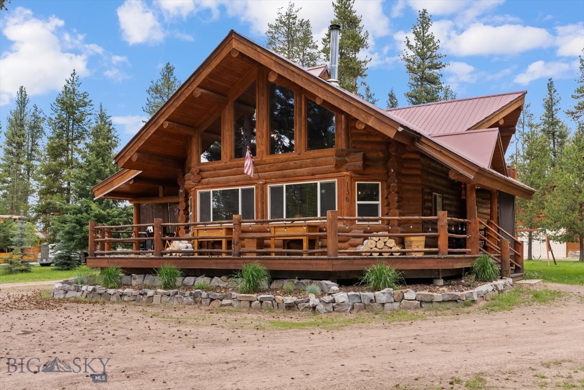 Custom Log Home located on one acre of flat forest land adjacent to the mountain recreation town of Seeley Lake. This spacious, quality log constructed home is comfort throughout with 3-bedrooms and 2.5 baths consisting of 2,720 sq ft plus large outdoor deck areas for relaxing and entertaining. Set up for visiting family and recreation there is a lot of space to spread out and enjoy the serenity of this area. The separate 32 x 36 ft. heated shop is finished for your projects and SXS and recreational toys. The shop includes 12-foot covered wings on each side for trailer and boat storage. Your arrival comes near the end of a paved road and begins with the stately log constructed covered entry port designed for unloading and parking. The open plan of the home is finished with vaulted log beam ceilings and large south facing windows providing excellent light and brightness with views of the scenic outdoors. On cooler nights and winter months, the oversized wood stove provides cozy warmth. The kitchen area features hickory cabinetry and granite countertops and is open to the main living area. The loft area is open with sleeping areas as well as a home office with outdoor views out the expansive windows. The lower level has a large closet/ gear room, sitting area one bedroom and bath. The landscaped areas are sprinkler irrigated and includes a fenced dog run area. Although the property is served by public water, there is a private well for irrigation or washing projects to create savings on your water bill. This property is easily accessed off of a paved road and is located only a few minutes from a public boat launch on Seeley Lake, restaurants, grills and watering holes, river and stream fishing, cross country ski and snowmobile trails, hiking and hunting. Although there is local shopping available, Missoula is one hour away for box store shopping and regional airline access.