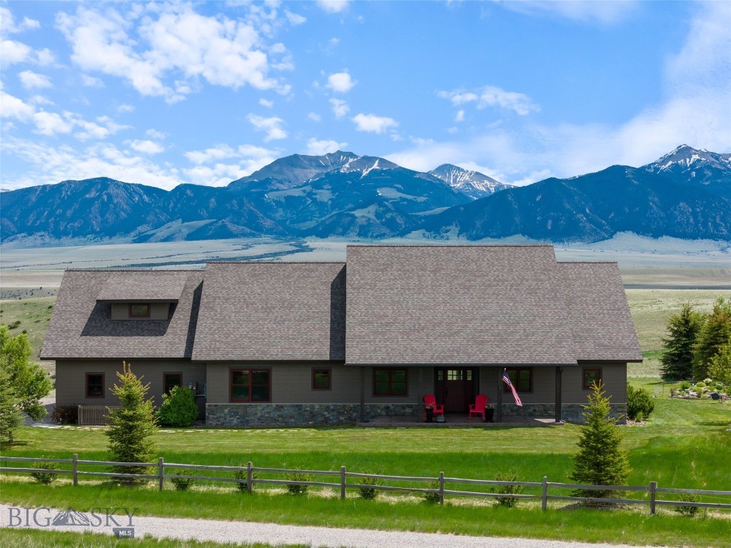 Welcome to a one-of-a-kind custom home on 7.260 acres in the coveted Pronghorn Meadows community, where luxury meets functionality and the views of the Madison Range stretch for miles. This thoughtfully designed 4-bedroom, 3-bath home offers 2,441 sq ft of refined living space — 3 bedrooms and 2 bath on the main level, with an additional private bonus room/bedroom above the garage complete with its own full bath and walk-in closet. Vaulted ceilings and engineered hickory floors welcome you into the main living area, while rich knotty alder trim, doors, and cabinetry carry throughout the home. The chef’s kitchen features a walk-in pantry, granite counters,  and a 5-burner gas stove (including one long burner) — perfect for hosting or daily living.
The primary suite includes French doors to the back patio, two walk-in closets, a double vanity, a walk-in custom tiled shower, and heated tile flooring. Two guest bedrooms with large walk-in closets and a full guest bathroom offer plenty of space for family or visitors.  Great storage throughout and a whole-house water softener, and solar panels for energy efficiency add exceptional value. Outside, enjoy beautifully landscaped grounds with two ponds and a waterfall, rock garden, raised beds, and a greenhouse. The stamped concrete patios are ideal for soaking in the peaceful setting. The attached 2-car heated garage is complemented by a third small bay with utility sink and additional storage. A 38x40 toy barn features a 14’ door and two 10’ doors for all your recreational needs. Two RV hookups complete this incredible property. Located just minutes from Ennis, the Madison River, and all that the Madison Valley has to offer, this home perfectly blends elegance, practicality, and breathtaking scenery.