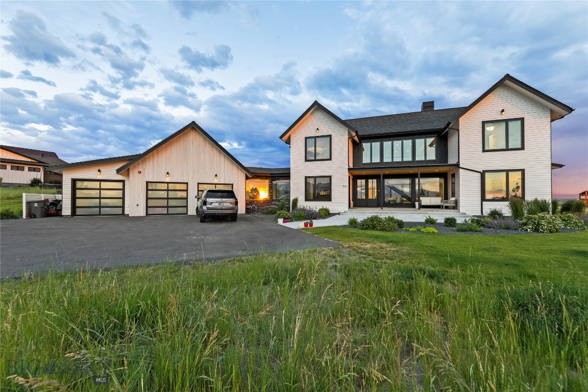 Perched atop the premier lot in Springhill Reserve, this stunning custom home captures some of the most breathtaking views in all of Bozeman. Set on 1.51 acres, the 4-bedroom, 3.5-bath, 3,577 sq ft residence was thoughtfully designed to blend luxury, functionality, and natural beauty. As you arrive via the tree-lined driveway, the panoramic views immediately impress. Inside, a chef’s dream kitchen awaits, featuring high-end Thermador appliances, including a built-in 36” refrigerator and 18” freezer, dual dishwashers, a built-in coffee station, oven, speed oven, and a 36” range. A custom dumbwaiter makes transporting items to the spacious upstairs living area effortless, where a built-in bar and expansive family room offer the perfect setting for entertaining. Wine lovers will appreciate the striking 150+ bottle wine rack—both a storage solution and a conversation piece. Throughout the home, 8-foot doors and high-end finishes reflect careful attention to detail. The lower-level living space boasts vaulted ceilings and a wood-burning fireplace with a gas-assist start, creating a warm and inviting atmosphere. Step through oversized glass doors onto the expansive south-facing patio, complete with a gas fireplace and sweeping views of the Gallatin Valley. The front office enjoys uninterrupted views of the Bridger Mountains, ideal for a serene work-from-home setup or a private fitness space. Each bedroom features custom closets, blending elegance with practicality. Outdoors, the property offers not only privacy and open space but also a dedicated, expansive fenced garden with raised beds. Perfect for seasonal plantings, or creating your own farm-to-table experience while taking in the surrounding mountain views. Ideally located just 4 miles from downtown Bozeman and 5 miles from Yellowstone International Airport, this home offers both convenience and serenity. Springhill Reserve residents enjoy nearly three miles of private walking trails, a tranquil pond, and over 50 acres of open space—making this property an exceptional blend of comfort, lifestyle, and location.