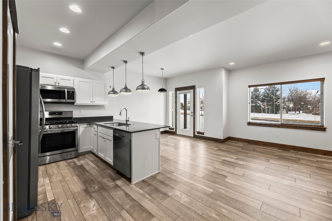 Welcome to this inviting 3-bedroom, 2.5-bathroom condo perfectly situated in the heart of Bozeman. The main level features laminate wood flooring throughout, a cozy gas fireplace, a functional kitchen with adjoining dining area, a convenient half bath, and direct access to the attached one-car garage. Upstairs, you’ll find a spacious primary bedroom with an ensuite bathroom, two additional bedrooms, a full bath, a dedicated laundry area, and a versatile loft/living space ideal for an office, media area, or playroom. This condo offers exceptional convenience with its central location—providing quick access to Montana State University, local shopping and amenities, and Yellowstone International Airport. Whether you’re seeking a full-time residence or an investment property, this home delivers comfort, practicality, and unbeatable convenience in one of Bozeman’s most desirable areas. *Photos of Unit B