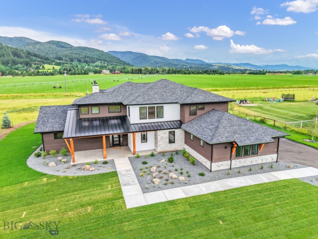 Set on over an acre in Hyalite Ranch, this newly completed custom home by Old Mill Homes was designed for buyers who want clean architecture, meaningful function, and the kind of quality that holds up long after the first showing. With 4,564 square feet, 5 bedrooms, 4 bathrooms, and a 3-car garage, the floor plan delivers what so many luxury homes miss: a large and livable main level, intentional separation between private and shared spaces, and the infrastructure to support real life at a high level.

The main living area opens beneath vaulted ceilings and a dramatic wall of glass, connecting the great room, dining area, and kitchen in a way that feels open without losing warmth. A gas fireplace grounds the room, while mountain views and southern exposure do the rest. Just beyond, a massive covered patio with its own fireplace creates a true extension of the living space, making it easy to enjoy outdoor dining, entertaining, and Montana evenings well beyond summer.

The kitchen is equal parts showpiece and workspace, finished with Thermador appliances, custom cabinetry, generous island space, and subtle details that elevate the experience, including LED under-cabinet lighting and luxury fixtures sourced from Arhaus, Lumens, and Restoration Hardware.

The main-level primary suite is where the house really separates itself. Spacious, private, and beautifully finished, it includes an oversized bath with heated floors, strong scale, and a custom closet that feels intentional rather than an afterthought. Upstairs, additional bedrooms, bathrooms, and flexible bonus space allow for guests, work-from-home needs, recreation, or multigenerational living.

Behind the scenes, the home is exceptionally well equipped with multi-zoned forced air heating and air conditioning, a humidification system, heat recovery ventilation, heated makeup air for balanced ventilation, radon mitigation, upgraded insulation, a whole-house water softener, 400-amp electrical service, wiring for EV charging and a hot tub, and selected windows pre-wired for electric blinds. Even the heated 3-car garage goes beyond storage, with a dedicated boot wash station built for Montana living.

This is a home that delivers the visuals buyers expect, but also the systems, comfort, and long-term quality they rarely find all in one place.  LANDSCAPING INCLUDED WITH PURCHASE.