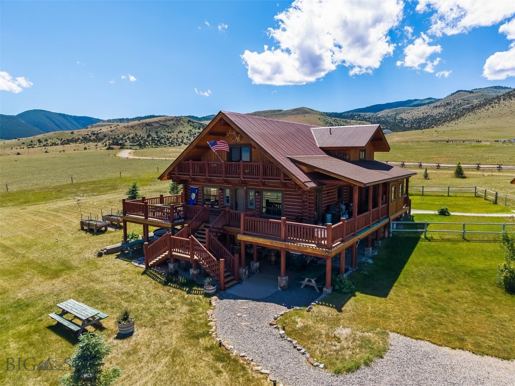 Experience Montana mountain living in this one-of-a-kind custom home where exceptional craftsmanship, artistic design, and breathtaking scenery come together on 10.39± acres in the sought-after Shining Mountains subdivision. With nearly 4,500 sq. ft., this 4-bedroom, 3.5-bath residence offers unobstructed views of the Madison Range from expansive wraparound decks and private balconies. The thoughtfully designed kitchen is a showpiece featuring custom cherry cabinetry with stained-glass accents, granite countertops, an eye-catching raw-edge granite island, labradorite and Oceanside tile backsplash, a 6-burner gas range, convection microwave, oven with warming drawer, and dishwasher. Engineered hardwood flooring extends throughout the main and upper levels, while soaring pine tongue-and-groove ceilings, solid wood interior doors, custom wire-brushed exterior doors, Hubbardton Forge lighting, art glass pendants, and custom sconces showcase the home's remarkable character and craftsmanship. The spacious primary suite offers a luxurious retreat with custom cherry cabinetry, dual vanities, a jetted soaking tub with heated backrest, tiled walk-in shower, and large walk-in closet. Upstairs, two generously sized bedrooms share a beautifully appointed bath featuring African slate, glass tile, and a solid granite stone sink. The walk-out lower level includes a large fourth bedroom with walk-in closet, additional living space, and abundant storage. The oversized attached two-car garage includes a self-contained studio with power, perfect for artists, hobbyists, a home office, or private workspace. Located in the Shining Mountains subdivision, property owners enjoy access to private Haypress Lakes, National Forest access, and miles of roads ideal for hiking, horseback riding, ATVing, cross-country skiing, and wildlife viewing. Just minutes from Ennis and the world-renowned Madison River, you'll enjoy outstanding blue-ribbon trout fishing, boating, hunting, and endless outdoor recreation. Bozeman and Bozeman Yellowstone International Airport are approximately an hour away, while Yellowstone National Park is just over an hour's drive, making this an exceptional full-time residence, vacation home, or Montana retreat where luxury and adventure meet.