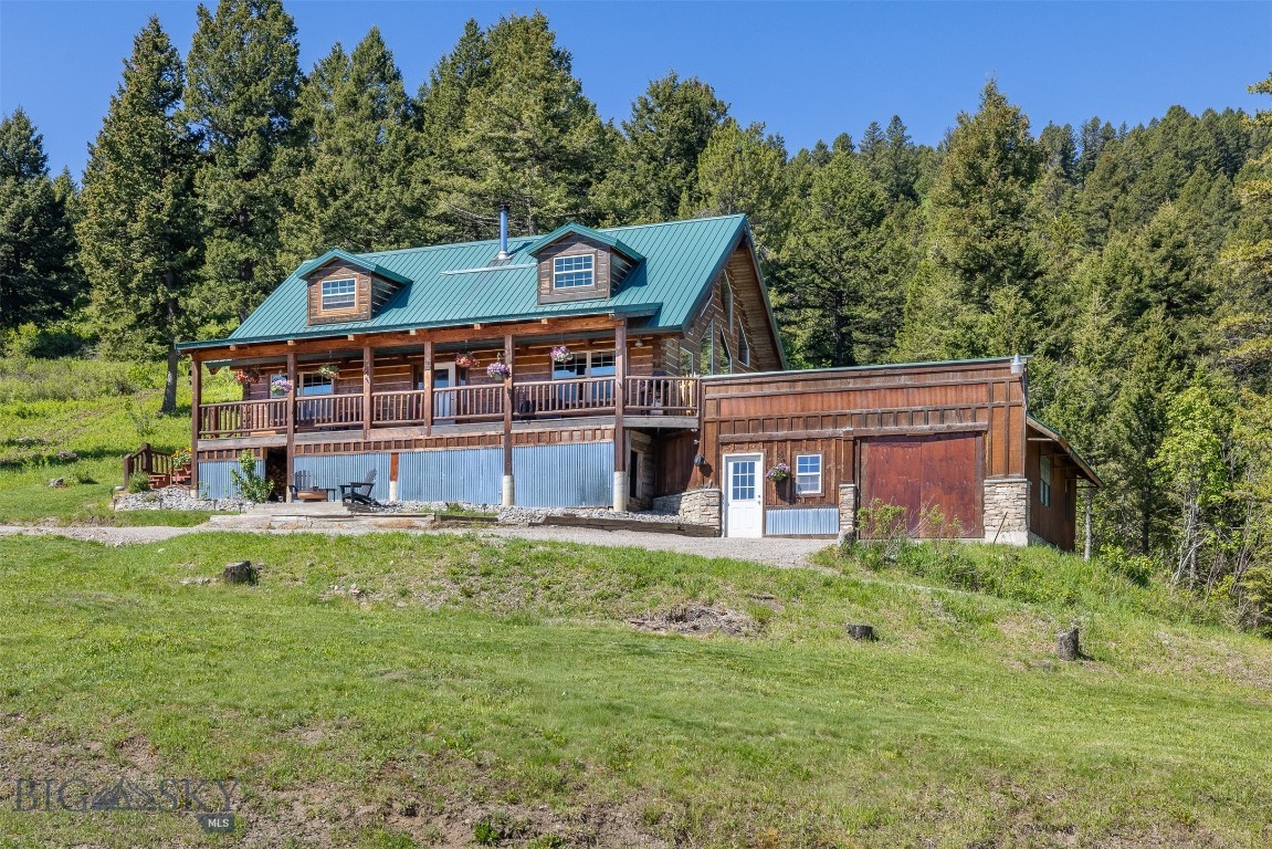 Twenty minutes from Bozeman. An hour and a half from Yellowstone National Park. A lifetime from ordinary.

Sitting on nearly 23 acres of Montana mountain terrain, this handcrafted log home delivers the setting most people only dream about — sweeping Bridger Mountain views, two on-site water wells, and a front-row seat to some of the most celebrated recreational country in the American West.

Built in 2001 with an eye toward both craftsmanship and livability, the home opens to a soaring great room where floor-to-ceiling windows pull the landscape inside. A wood stove anchors the space on crisp Montana evenings, while solid wood cabinetry and updated stainless appliances make the kitchen equally suited for a quiet weeknight or a full house after a day on the mountain. Step onto the covered balcony to take in the views, or drop down to the covered patio and ease into the hot tub — it works beautifully in any season.

Four bedrooms and three bathrooms are arranged with genuine privacy in mind. Two primary suites each offer en suite baths: one in a loft overlooking the great room and mountains beyond, and one conveniently on the main floor. The fully finished lower level functions as a guest suite or multi-generational retreat, complete with two additional bedrooms, a bathroom, and a kitchenette.

The property is thoughtfully equipped for horses or livestock, featuring cross fencing, a horse shelter, and a small barn that add both function and flexibility to the land. Two wells on the property aren't a footnote — they're infrastructure. Whether you're thinking horses, irrigation, livestock, or simply the peace of mind that comes with self-sufficiency, that kind of resource matters in Montana.

World-class skiing, blue-ribbon trout fishing, hiking, hunting, and the unmatched draw of Yellowstone are all within reach. Bozeman's airport and amenities are twenty minutes away — close enough to be convenient, far enough to feel like you've truly escaped.

This is Montana the way it's supposed to be.