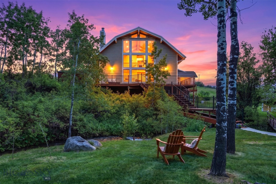 Nestled in the highly sought-after SpringHill Community, this breathtaking 5.28-acre property, situated in the midst of large acreage farms, offers the perfect blend of privacy, natural beauty, and Montana living. As you make your way down the private drive, you’re immediately greeted by stunning panoramic views of the Bridger Mountains, a truly unforgettable approach to an extraordinary property. Picturesque Ross Creek winds through the entire property, creating a peaceful and serene setting. The dramatic entry stairs cross directly over the flowing stream, setting the tone for the tranquil retreat that awaits. Towering aspen trees surround the home, giving you the feeling of having your own private forest, complete with multiple secluded spots to relax by the water and enjoy nature. Designed with both comfort and functionality in mind, the property features horse-ready amenities including open grazing pastures, bubbling spring for year round water for livestock, a hay barn, and tack room. A garden area with orchard adds even more charm to this remarkable setting. Completely private and hidden from Walker Rd, this property offers a rare sense of seclusion while still being conveniently located to everything Bozeman has to offer. The home itself is warm, inviting, and spacious, offering 4 bedrooms and 4 bathrooms across three levels. The main level features a luxurious primary suite with a full bathroom, jetted tub, and an additional half bath. Inside the main living area, you’ll find a stunning cobblestone fireplace, an open-concept kitchen, and expansive windows that perfectly frame the surrounding Bridger Mountain views and natural landscape. Upstairs features two additional bedrooms, a 3/4 bathroom, and loft space, providing plenty of room for family or visitors. The fully finished walk-out lower level includes a large bedroom, family room, 3/4 bathroom, and direct access to the backyard—ideal for guests, entertaining, or multi-generational living. A wraparound deck accessible from multiple areas of the home allows you to fully embrace the peaceful surroundings and breathtaking scenery from every angle. Additional features include a detached, oversized, two-car garage with private studio apartment complete with 3/4 bathroom — perfect for guests, rental income, or a creative workspace. There are 5 water rights that convey with this property. No Covenants, No HOA. This is a rare Montana dream property offering unmatched beauty, privacy, and lifestyle.