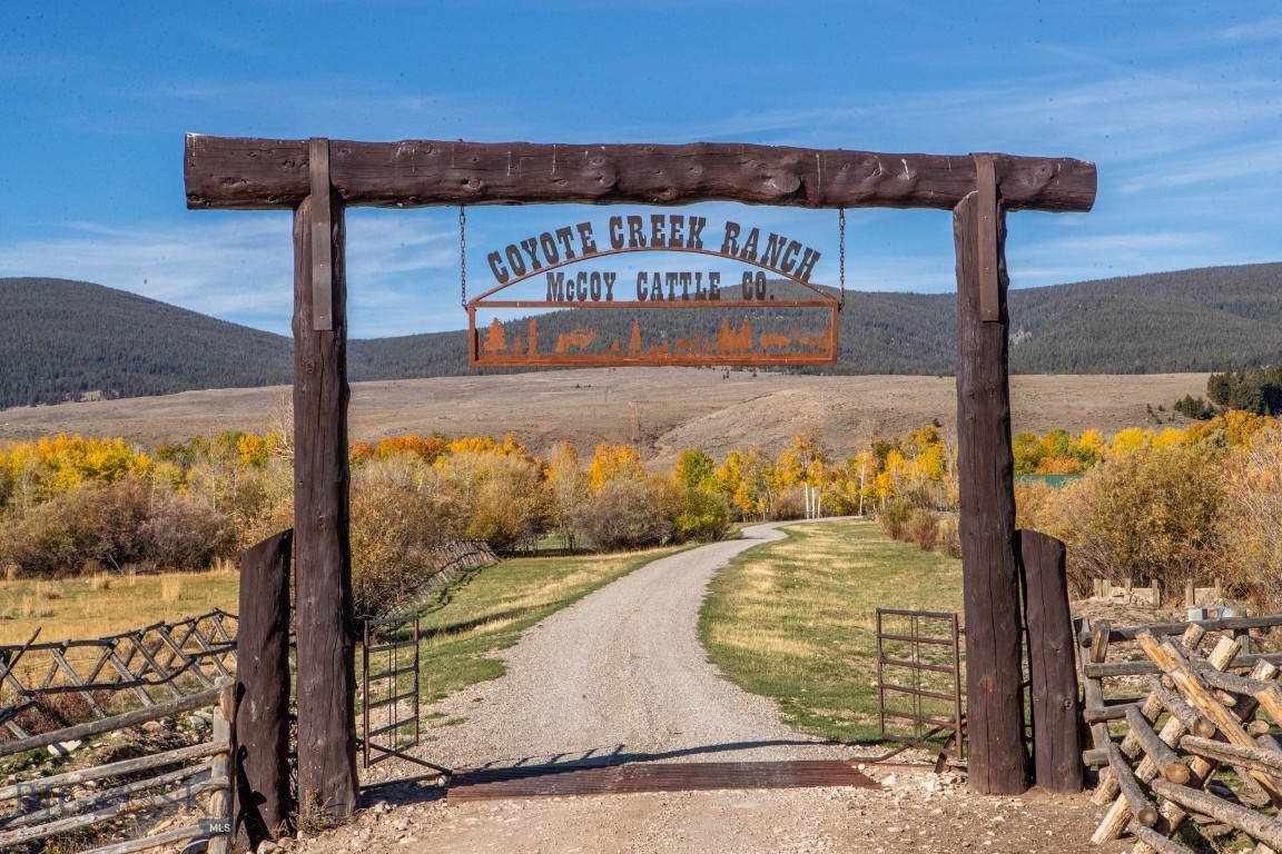 Nestled in the heart of Montana ranch country near Grant, the Coyote Creek Ranch encompasses 2,802± deeded acres surrounded by breathtaking views of the Pioneer Mountains. Steeped in history, this region of Horse Prairie is where the Lewis and Clark Expedition met Sacagawea’s Lemhi Shoshone people in 1805—an area long valued for its open grasslands, water, and early ranching heritage.
Coyote Creek Ranch is a rare combination of productivity, recreation, and beauty. The property features abundant live water from Coyote, Jensen, and Lodgepole Creeks, plus a well-stocked trout pond. Approximately 770± acres are irrigable, providing fertile meadows for hay and grazing. Sub-irrigated and flood-irrigated bottoms are lined with aspens, meandering creeks, and rich wildlife habitat. The ranch also includes valuable grazing leases on adjoining USFS, State, and BLM lands. Conservation Easement.
Currently operated as a summer grazing unit, the ranch has historically supported around 500+/- cow/calf pairs each summer for a 5 month season, utilizing both deeded and leased acreage. In 2025, the owner successfully ran 300+/- pairs and 300+/- yearlings during the most recent season.  Fully fenced and cross-fenced with well-designed corrals, this is an efficient operation with dependable carrying capacity and diverse forage.
For the sportsman, Coyote Creek Ranch is an outdoor paradise. Wildlife is abundant—elk, whitetail and mule deer, moose, bear, upland birds, and trout thrive here. Located in Hunting District 329, the ranch lies within an over-the-counter elk area for residents and borders thousands of acres of public land, offering exceptional hunting and recreation year-round.
Improvements balance rustic charm with modern function. The Whisper Creek log home overlooks the trout pond and Horse Prairie, featuring 3 bedrooms, 4 baths, a primary suite with jetted tub and walk-in tile shower, and a finished walk-out basement with family and rec rooms. A wraparound porch captures sweeping 360° views. A detached 30' x 45' garage provides ample storage. The guest or manager’s home includes 3 bedrooms and 2 baths for comfortable living. Don't forget about the trapper's bunk house too! A 40' x 60' Cleary building with horse stalls, tack and feed areas, and covered overhangs completes this well-equipped ranch headquarters.
Coyote Creek Ranch offers the ideal balance of production, recreation, and Montana beauty—a true legacy property beneath the Big Sky.