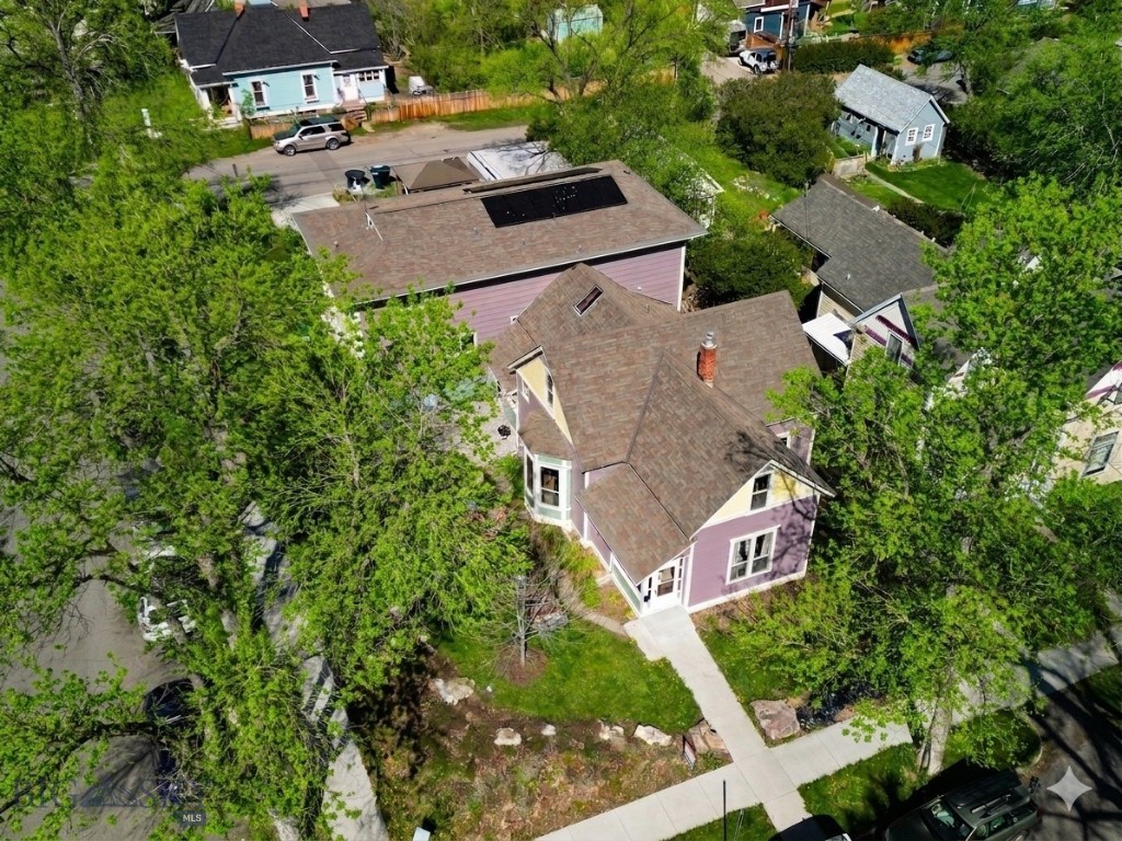 Opportunity knocks - This unique and high performing triplex offers a trifecta of built-in value: a historic footprint, a proven income stream for over 25 years and a coveted location in the heart of historic Bozeman. Fully rented and priced to sell at a 6.5% cap rate, the property consists of three intentionally built units - not a divided up house. First time on market in over 25 years! Situated just blocks from Main Street shopping, dining and amenities and minutes to Montana State University, this property is the perfect blend of location and lucrative investment potential. The front unit is a charming Queen Anne style two story home – known as the Susan Kirk Residence. Featuring up to 5 beds: 4 conventional beds plus a walk-through flex/office and two baths. The main floor features spacious living areas, kitchen and bath. The home has been well maintained and includes a side driveway for parking, enclosed front and rear entryways and retains its historic charm with colorful paint and gingerbread elements including scalloped shingles and a variety of exterior siding textures. An attached duplex features Piping Plovers from the Craigshead Institute’s Murals of threatened and Endangered Species Project. The duplex consists of two side by side units, each with 5 bedrooms and 2.5 bathrooms, featuring spacious living and kitchen areas and additional flex space. An expandable rooftop solar array is connected to the north duplex unit and features EV charging. Concrete parking area features parking for 4 vehicles. A 2-car detached garage is currently used by the owners includes space for a shop/storage. There are several communal bike storage areas on the property including a covered pavilion. Yard spaces have been improved with thoughtful native landscaping and raised garden planters for the occupants to enjoy. Mature trees and shrubs allow for privacy and shade in summer. Many possibilities exist to make the property your own (maintain/condex/development). This is a wonderfully convenient southside Bozeman location – only minutes to Montana State University, hospital, shopping, breweries, music venues, grocery stores, restaurants, services and amenities. Only 25 minutes to Bridger Bowl, 30 minutes to blue ribbon fly-fishing and river recreation, and 1 hour to Big Sky.  Please don’t disturb the tenants – shown by advanced appointment only.  Don’t miss the VR Matterport Tour.