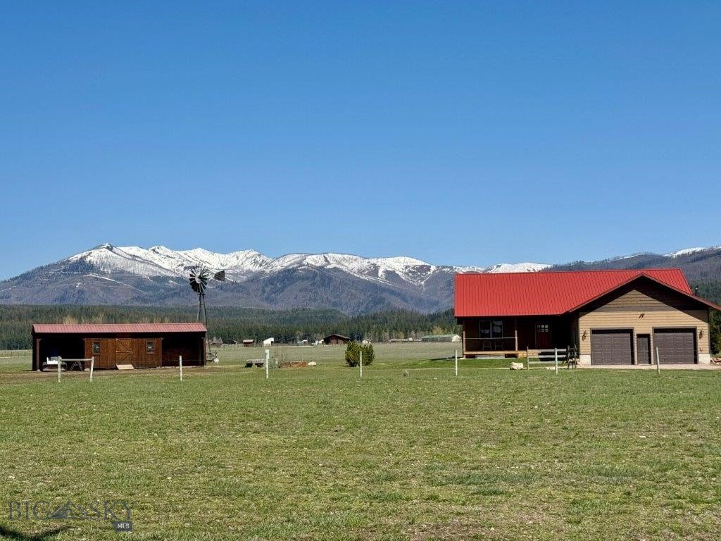 The Wilderness View Home is situated on 20 acres in a beautiful meadow among neighboring ranches near trailheads leading into the Bob Marshall and Scapegoat Wilderness areas. This immaculately maintained home is 1944 sq ft, 3 BR, 2.5 BA. The spacious floorplan is open with vaulted ceilings, lots of natural light and magnificent views of your hay meadow and snowcapped mountain peaks. The home has beautiful, weathered wood laminate flooring throughout. The thoughtfully designed kitchen has lots of counter space and red maple cabinets, a gas range, plus a large kitchen island all with Corian countertops. The primary bedroom features mountain views, full bath with walk in shower and walk in closet. The two guest bedrooms would allow for one of them to be dedicated to a home office with lots of light and mountain views. The home is finished with a UV Water system, propane forced air heat and wood heat as well as central air. Front covered deck with lots of sun and a back covered Trex deck where you can enjoy the mountain views with opportunities to watch elk, whitetail deer, and waterfowl passing through the property while enjoying evening relaxation. There are several outbuildings that perfectly complement this country property including a 40 x 60 pole shed with 3 stalls, a 12 x 45 shed featuring 2 bays for a tractor or side by side including a nice 12 x 20 shop with electric, plus a general storage shed, and a chicken coup. The property has no restrictive covenants and is fenced for horses or livestock and and can generate about 10-12 tons of hay. If you are an outdoor enthusiast, you have nearby access to over 1.2 million acres of wilderness to explore. You can trail your horse over thousands of miles of trails leading to and within the wilderness areas. A short drive away and you can be fishing on the world-famous Blackfoot River and several options of smaller lakes and streams. You can take a side by side from the property over many scenic mountain roads. This property is in Powell County, desired for its rural, ranching character, lower property taxes and less regulations than nearby counties. The town of Seeley Lake is about 20 minutes away and offers small town shopping, restaurants, a bank and a clinic. The historic community of Ovando has a small general store, a fishing shop, and two restaurant options along with a tavern. Missoula is located about one hour away with big box shopping, college sports and an airport served by major airlines.