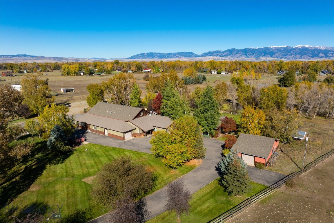 THREE DWELLINGS, 11+ ACRES, TWO SHOPS, LIVE WATER & LIMITLESS OPPORTUNITY. This multi-family compound is situated on 11.5 acres with the beautiful Baker Creek flowing through, incredible Bridger Mountain Views, huge equipment storage, and lush livestock pastures. The main house includes 3 bedrooms, 2 bathrooms, dedicated office space, multiple flex rooms perfect for in home gyms, game rooms, dens and more. Upstairs, there is a large and comfortable 2 bedroom, 1 bathroom, fully appointed apartment with it's own private entrance. The attached shop space is unparalleled, with a heated 3,250 sqft complete with a full kitchen, bathroom, built-in storage, attached additional workshop, and drain system. If that storage space isn't enough, also included is an additional detached, 1,092 sqft shop and two more additional garage spaces. The 5 star level 10 Exceptional Rated guest cabin, affectionally known as the "Cabin Sweet Cabin" has been beautifully renovated boasting 3 bedrooms, 3 bathrooms, a loft, covered patios, hot tub and more. Currently used as an extremely successful vacation rental, the guest cabin is sold beautifully furnished and turn key as an income producing property. There are minimal covenants and no HOA here. This property was formerly home to a large scale construction company and promotes itself so well to live/work opportunities, while simultaneously offering guest space and SUBSTANTIAL rental income production. This property could easily accommodate multi-generational living or serve as simply an incredible investment opportunity with several rental income avenues. Located at the very end of the road, bask in a quiet, rural setting with fenced livestock pastures, chicken coops, firepit, irrigated garden areas, a beautiful creek that attracts regular local wildlife, mature trees, and a Bridger Mountain backdrop. This home is truly unique and provides soo many opportunities that are becoming increasingly difficult to find. Located off of Amsterdam road, your commute to Bozeman, Belgrade, Manhattan and the Bozeman Airport are a breeze. Let your imagination run wild and make this your dream HOME SWEET MONTANA HOME today!