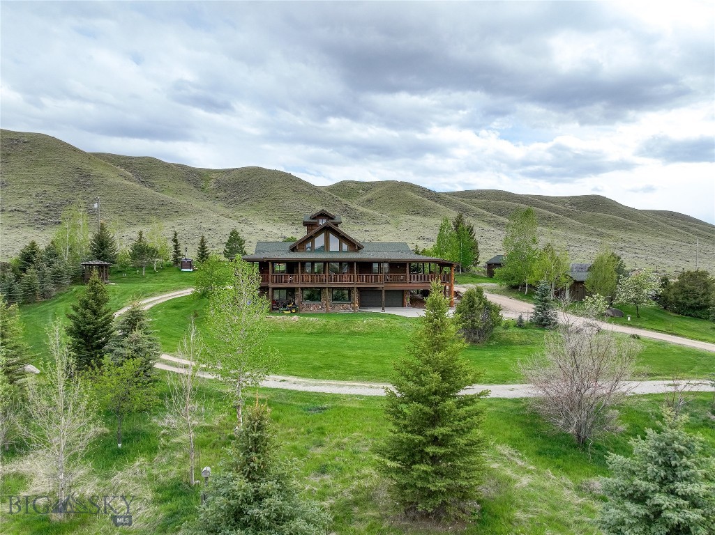 When you enter through the majestic gate you know that you have arrived somewhere special.  This handcrafted log home on two acres is a rare property located in Jeffers.  The attention to detail and the many custom features provide a rare quality letting this home stand out from other log homes.   The upgrades include radiant in-floor heat, vaulted ceilings, unique lightning struck matched log stairs and railing, solid wood floors and sweeping porches to embrace the stunning mountain and ranch views. Leave your loft level office to find inspiration above in the cupola with incredible views that stretch across the valley.  This home is well laid out with plenty of storage and extra space for company or hobbies.  Mature landscaping and extra outbuildings (sleeping cabin, workout area/shop and gazebo) add to this property that has no covenants and borders a large ranch on two sides.  The views are ever changing with the light from morning to night and you will never tire of observing the ospreys nesting in the nearby legendary nest.  Jeffers is a charming rural community just outside of Ennis, MT and close to nearby trailheads and Ennis Lake.  Skiers can benefit from the Jack Creek Road access to Big Sky Resort.  This quality home in a country setting is a must see and an additional 2 acres may be available.