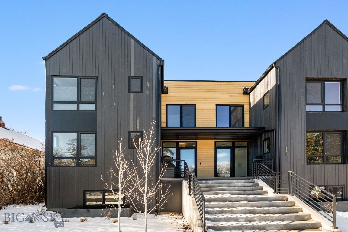 In the heart of downtown Bozeman, this high-end Scandinavian style townhome is ideally located between Montana State University and downtown. Perfect for walking to dining, shops, coffee, breweries, and parks while enjoying a peaceful home. The main house boast 4 bedrooms and 3.5 bathrooms, along with a full ADU guest suite above the detached garage, and the property comes fully furnished. 
Throughout the home you have natural light coming through the large energy efficient windows, all of which have new custom window coverings. Entering on the main level you have an open-concept living area. Here you have your living room that includes a sleek gas furnace, a very spacious well designed kitchen with walnut cabinetry, shaker wood cabinets, quartz countertops, large walk-in pantry, a full wet bar with beverage center and wine fridge, along with the dinning area. A stainless steel Bertazzoni 36" dual-fuel range is the center piece between the paneled counter-depth Bertazzoni refrigerator and framed by the two vertical windows and exposed wood beams. Off of the dinning area a large glass window and door allows access the outdoor patio, which is ideal for family and gatherings. 
The top floor has the large primary suite, including the master bathroom area with a combination of wood accents, concrete and marble, a fully tiled walk-in shower area with a soaking tub and built in towel warmer. The master walk-in closet is directly connected to the bathroom area. The second suite bedroom is down the hall and sits opposite the primary, with an upper floor laundry area in-between. The basement level offers two additional bedrooms, a full bathroom,  additional laundry area closet and the extra large living space that is ideal for lounging, a theater room or a secondary living room. 
The home includes a full 2 car garage and a private guest apartment above, offering an additional bedroom, bathroom, walk-in closet, washer/dryer combo laundry, kitchen and sitting room. This home is wired for solar panels and has electric vehicle charging outlets in the garage. A large partially covered patio is fully furnished and has a new ceiling mounted radiant heater, that is great for enjoying the outside area during cold nights! This perfectly designed modern three-level townhouse offers an exceptional opportunity to experience the very best of Bozeman.
