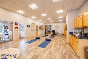 This unique property offering spans approximately 4,732 square feet, and includes 18 treatment rooms/office suites and a spacious studio designed to accommodate a wide variety of uses, workshops, educational gatherings, and other assorted events.  It is currently being utilized for wellness-related activities & classes. 

Unit F serves as the primary reception and waiting area and is defined by its bright, open-concept layout. The suite includes a front desk, attached kitchenette, six treatment rooms, additional storage space, and double doors leading to a covered deck with beautiful south-facing mountain views.

Adjacent Unit G features a large studio space currently utilized for wellness practices, formal and informational classes, and community gatherings hosted by practitioners. This suite also includes five offices, a storage closet, a sink with granite countertops and cabinetry, and oversized double doors opening to a covered deck with stunning northeastern views of the Bridger Mountains.

Located across the hallway, Unit E consists of seven additional office suites rooms primarily occupied by wellness practitioners. Several of the offices are plumbed for sinks, and the unit also includes a spacious storage closet with washer and dryer hookups. Each treatment room has been thoughtfully designed to comfortably accommodate massage tables and wellness furnishings while maintaining ample circulation and functionality. Notably, 10 of the 18 treatment rooms feature windows, offering abundant natural light — a distinctive feature rarely found in comparable wellness or office spaces.

The HOA is in strong standing and has recently completed significant exterior upgrades to the property. Additional amenities include elevator access to the second floor, shared common-area restrooms, individual A/C units for each suite, extensive on-site parking with 25+ dedicated spaces, and abundant off-street parking for clients and guests.

While the current wellness-centered environment offers strong synergy and continuity, the property also allows flexibility for a wide range of professional or commercial uses.  Additionally, Units E, F, and G are legally distinct units and may be sold separately, offering flexibility for phased ownership, investment strategies, or future resale opportunities.