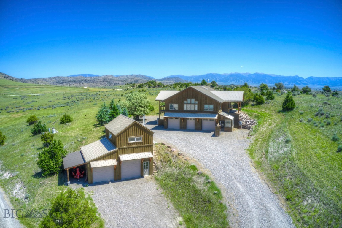 Never before offered, this architecturally designed Craftsman timber-frame home is set on 22.3 acres, thoughtfully nestled into the hillside to capture sweeping mountain, river, and valley views in every direction from property. Surrounded by striking natural rock outcroppings, the property offers a true Montana setting.

Inside, the open-concept design creates a sense of grandeur, centered around a stunning staircase with modern cable railing that puts the home’s exceptional structural engineering on display.

The upper level features a massive great room with an open kitchen, while the primary en suite captures stunning Tobacco Root mountain views. A second bedroom and bathroom are conveniently located on the same floor. Designed to fully embrace the setting, the expansive deck and doors create exceptional opportunities for indoor-outdoor living. 

The lower level offers a spacious bedroom with a wood stove, a laundry room and another bathroom.  An attached 3-car tandem garage features an additional overhead door for easy access to a riding mower or ATV. An attached greenhouse allows you to extend your gardening season and protects your tomatoes from the abundant deer throughout the community!

Complementing the property is a 1,144 SF shop, featuring a 416 SF upper level with electric baseboard heat and a wood stove, and a 728 SF lower level ideal for RV parking, storage, or workspace. With septic approved for four bedrooms, there is room to grow, offering the potential to convert the shop into an additional living space, if desired.

Designed with comfort and practicality in mind, the home includes air conditioning, a whole-house reverse osmosis system, French drains in the driveway, and a backup generator. 

Neighborhood includes private access to 2.5 miles of Gallatin River, 640 acres of state land, and a beautiful river- front pavilion, fire pit and BBQ area. Providing you and your guests, an unmatched lifestyle for fishing, recreation and outdoor entertaining. Located in desirable Manhattan, only 30 minutes from downtown Bozeman with its shopping and fine dining.    

This is a rare opportunity to own a one-of-a-kind timber frame home where architectural design, craftsmanship, and the surrounding landscape come together in perfect harmony.
