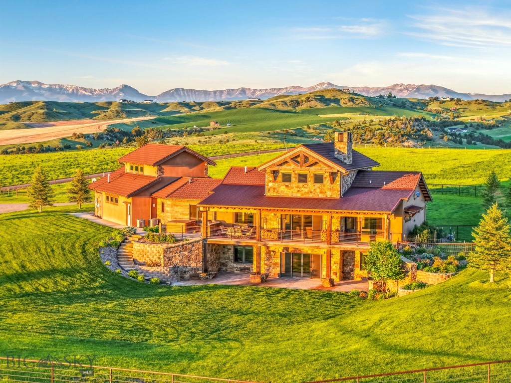 Set on 20 acres of gently rolling land, this 4,682 sq. ft. custom-built estate offers a rare blend of luxury, comfort, and functionality in a truly breathtaking setting. Surrounded by uninterrupted views in every direction, this property embodies the essence of refined country living.

Step inside to a grand living area featuring striking stonework, a soaring fireplace, and expansive sliding glass doors that frame the sweeping landscape and open to a spacious covered deck—perfect for outdoor dining and relaxation.

The gourmet kitchen is designed for both style and performance, boasting premium Thermador appliances—including double wall ovens, a paneled refrigerator, 6-burner cooktop with griddle, and Bosch raised dishwasher—alongside a generous island, extensive counter space, and a large walk-in pantry.

The main-floor primary suite offers a tranquil retreat with spa-like amenities, including a copper soaking tub, dual vanities, and an in-closet washer and dryer. Completing the main level are a mudroom with sink and storage, a three-quarter bath, and a versatile bonus room above the three-car garage that can serve as a fourth bedroom, studio, or office.

The daylight basement extends the home’s living and entertaining space with large view windows, a family room with wet bar, access to a covered patio, two bedrooms, two full baths, a laundry room, and a flexible area ideal for a home theater, gym, or recreation zone.

Designed with equestrian enthusiasts in mind, the property features a large barn with a 2-bedroom, 1-bath apartment—ideal for guests, caretakers, or rental income. The smooth wire electrical perimeter fencing, corrals, and open pastures make this an ideal setup for horses or livestock.

From its rolling topography to its high-end finishes, this remarkable property delivers the ultimate blend of sophistication and rural beauty.

Experience the freedom and serenity of estate living—schedule your private tour today!