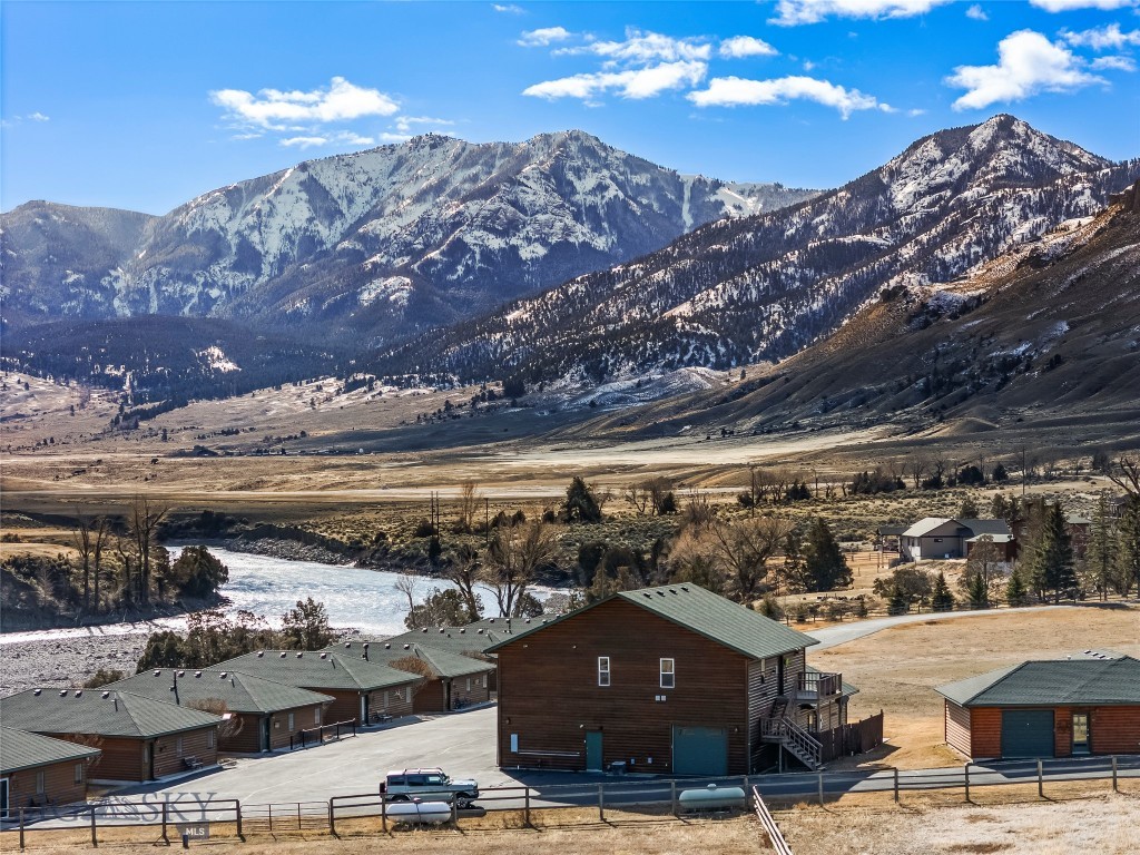 Ready to experience Wonderland up close and personal? From the time you turn off 89 S, you will see what makes this area special. From Devil's Slide to Electric Peak, chances are high that you will see migrating animals, resident big horn sheep, and soaring eagles as you make your way to your warm and welcoming condo on the banks of the Yellowstone River. This 3-bedroom, 2-bathroom condo has mountain and river views. Upon entering the condo, you will find a bright office for catching up on business. One guest bedroom is located off the front hall. The large family room features vaulted ceilings that frame views of Electric Peak and the great lawn.  A beautiful stone-work hearth creates a striking focal point with an electric fireplace. The second guest bedroom is just off this room. The primary bedroom has an en-suite with a large walk-through closet.  The spacious kitchen is equipped with a refrigerator, dishwasher, range with two ovens, and microwave. The enchanting dining room will be a favorite gathering spot after a day of exploring your surroundings. The laundry room includes 2 washers and 2 dryers, with ample storage, and is right off the dining room. The attached garage is currently disguised as a game room, but it could easily be converted back to its original purpose. There is a detached garage to round out this unique property. Community access to the Yellowstone River, the great lawn, and community fire pits is included in the condo association. You can drive to Roosevelt Arch on Old Yellowstone Trail and feel as if you are experiencing your own private Yellowstone. Whether this becomes your Lock-and-Leave or Full-Time residence, you will love the location, with its close proximity to YNP and heart-pounding adventures!  Call your preferred Realtor and schedule a showing today!
