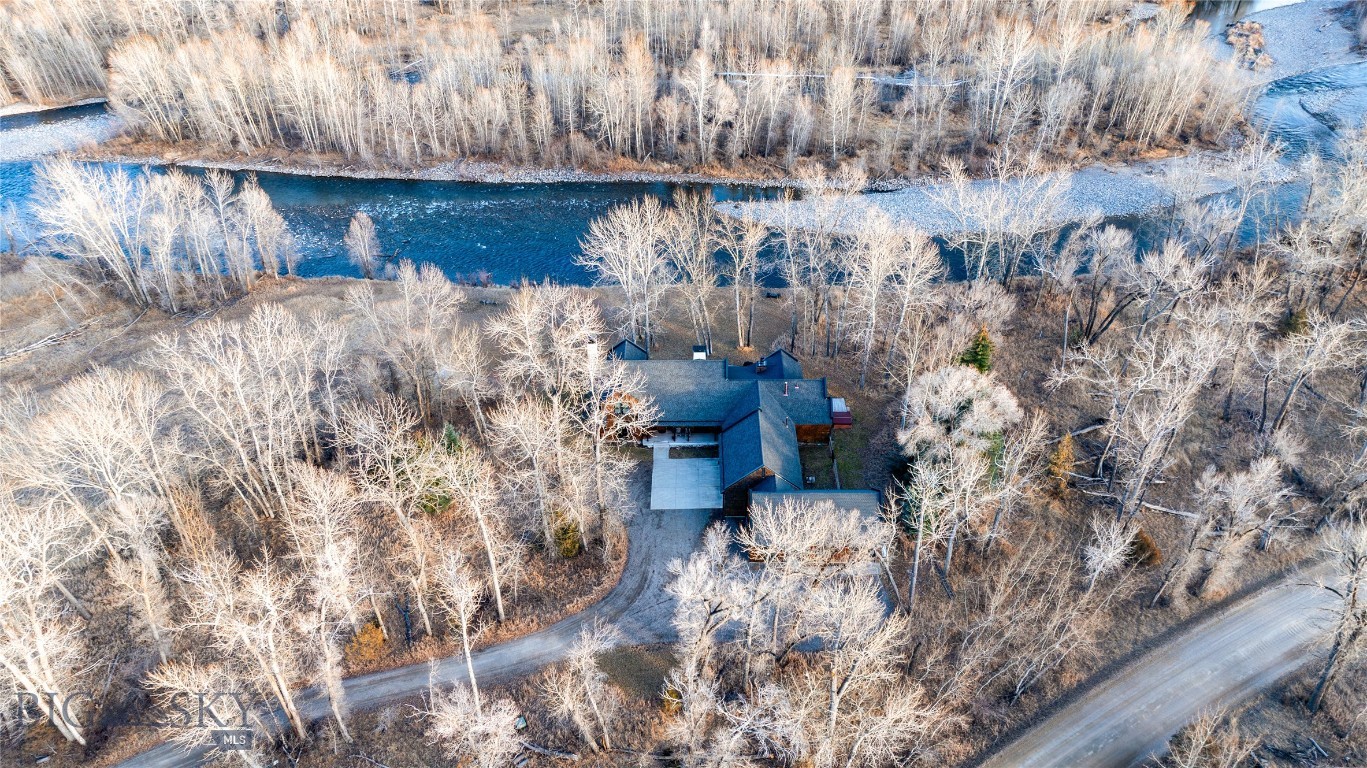 Tucked along the banks of the famed Gallatin River South of Bozeman you will find 40+/- acres with over 1/2 mile of prime river frontage. The 4013+/- sqft 4 bed 3.5 bath home designed by Van Bryan Architects embraces nature to the fullest. An open floor plan with expansive epicurean kitchen, etched concrete floors, radiant heat, 5 sets of  glass French doors, numerous windows and thoughtfully placed skylights that flood the space with warm light and river views. The living room has a gas fireplace and raised seating area with wet bar -it is the perfect landing spot to relax, visit and watch the river. The master bedroom is complete with large steam shower, travertine gas fireplace, double sinks, a seated vanity and large walk in closet. After a hard day of play, soak in the hot tub just outside the bedroom door. The laundry room and large mud room area complete the area attaching to the 2 car heated garage. Traveling up the floating staircase you will find two bedroom suites with full baths and a work area overlooking the river ,a perfect area for tying flies! On the W side of the house lies an attached 733 +/- sqft guest cottage with private entrance and 1 car heated garage. Natural light illuminates the 1 bedroom 1 bath space and it is self-sufficient with a laundry closet, living room, full kitchen and mud room area. Outside there are several inviting gathering places and a wood burning fireplace with river views. Walking the grassy path along the river you will find the historic 1919 Cabin where you can step back in time. The 1919 Cabin is perfect for day use, a studio or parties. (cannot be used as a living space). A wide variety of wildlife abounds in this ideal riparian habitat and river corridor. The fishery in this stretch of the river does not get much pressure due to the location, and encompassing both banks of the river, it presents an angler with more casting opportunities! There are too many incredible attributes of this special property to list here. It is a must see in-person offering. Location is key - just 20+/- minutes from downtown Bozeman - 78+/- miles to W entrance to Yellowstone National Park - 15+/- miles to Bozeman International Airport and close proximity to thousands of acres of public land for recreating. Stacey's Bar and Steakhouse is just down the road a piece. The property is protected in a conservation easement with Gallatin Valley Land Trust. The current owners stewardship shines through. Located between Bozeman & Big Sky!