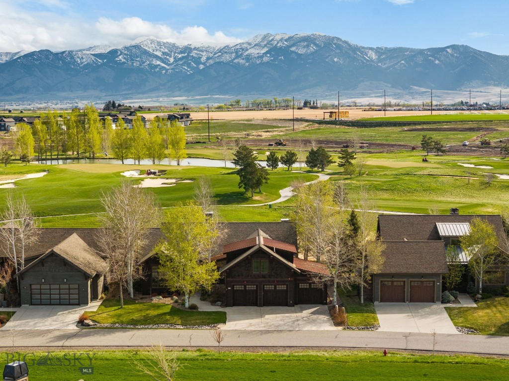 This is the location everyone is searching for -- unobstructed Bridger range views over open space and the golf course. A quintessential location in one of Black Bull’s most coveted settings, this Locati-designed home captures sweeping Bridger views across open space and the quiet backside of the golf course—creating a rare sense of privacy, serenity, and connection to the landscape. A spring-fed creek meanders behind the home, while park space across the street enhances the peaceful, open feel, all just a short walk to the club’s fitness center, pool, and private restaurant. Thoughtfully built with quality craftsmanship and timeless Montana finishes, the home offers four private bedroom suites—three on the main level, including a flexible lock-off option for guests or caregivers, and a spacious upper-level suite ideal for additional living, office, or wellness space. The main living area is designed to showcase the incredible views, featuring floor-to-ceiling glass, soaring ceilings with wood beam accents, a stone fireplace, a wet bar with beverage fridge and custom built-ins. Outdoor living is equally refined, with a covered deck and stone wood-burning fireplace perfectly oriented to take in the expansive mountain backdrop year-round. A heated three-car garage provides ample space for vehicles and toys. A must see property. Located on a quiet street, just steps from club amenities including pool, fitness center, private restaruant, and award winning Black Bull golf course.