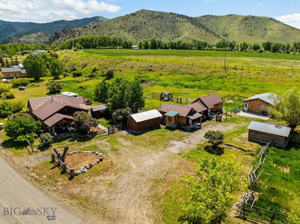 Tucked just under 3 miles from the picturesque town of Sheridan, MT, this unique 2.4± acre property offers a blend of comfort, versatility, and rustic charm. The main residence features 2 bedrooms and 2 bathrooms (one full & one half) with distinctive blue pine ceilings and walls that create a warm, inviting atmosphere. Step outside onto the covered deck and enjoy peaceful views surrounded by mature aspen and willow trees, along with established apple trees and raspberry plants that should be ready to harvest next year. Additional living and functional spaces include a 1 bedroom, 1 bathroom guest cabin, a detached dry cabin with electricity and heat—ideal for an office or creative studio—and a historic dry homesteader’s cabin offering added character and storage potential. A 10' x 20' workshop with concrete floor and 220V power provides space for projects or hobbies, while a 24' x 32' detached garage/shop with 220 V power delivers ample room for equipment, toys or additional workspace.Located off Mill Creek Road, the property provides quick access to public lands, creeks, and lakes—perfect for those who love the outdoors. Whether you're seeking a full-time residence, multi-use retreat, or homestead with space to grow, this special property offers Montana living at its finest.