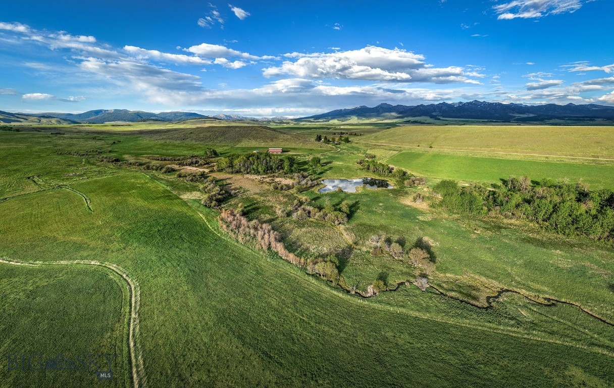 Porcupine Creek Homestead is made up of 116± acres located in the coveted Shields River Valley east of the small town of Wilsall and an hour from Bozeman. The property is a blend of cottonwood and aspen grove riparian areas bifurcated by small flowing springs, two ponds, and valley views that encompass the Crazy Mountains to the east and the Bridger Range to the west. Once owned by a prominent Livingston banker, he built the historic Victorian-style home, which became the centerpiece of the property. In 2005, a restoration project began, and the house was effectively recreated to its exact dimensions and vernacular. This small two-bedroom one-and-a-half bath was masterfully re-created and appointed in a charming way. A six-stall horse barn was added near the residence with a large two-bedroom apartment that lofts overhead and sits next to a spacious two-car garage. Several years ago, a large trout pond was created for aesthetic and recreational purposes with a secondary primary building site in mind. The property is well-kept, and the hayfield is managed appropriately to produce forage crops and attract the multitude of wildlife that exists there, including whitetail deer and moose. Porcupine Creek Homestead is an easy-to-own property with nicely appointed improvements in proximity to Bozeman, Livingston, skiing, and the lively aspects of these desirable mountain communities, yet far enough away to find solitude in a highly sought-after river valley.