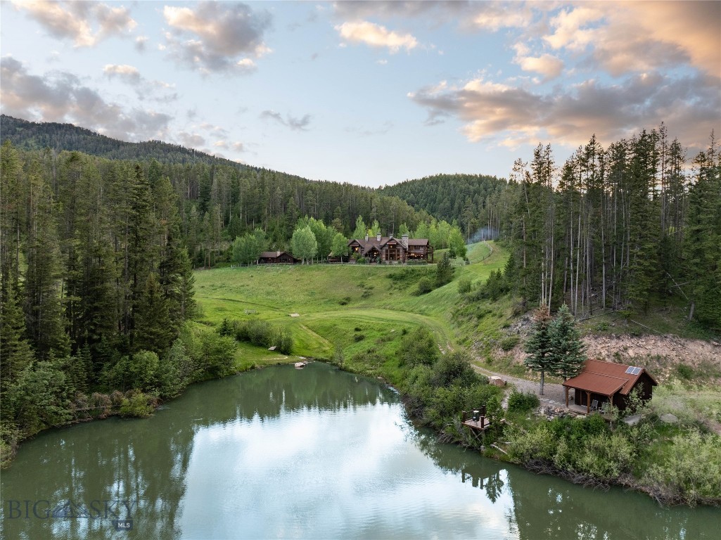 Hidden within the coveted Goose Creek corridor lies one of Southwest Montana's most extraordinary legacy estates. Encompassing 60.16± acres across three separately deeded parcels, this exceptionally private retreat combines timeless craftsmanship, breathtaking natural beauty, and a level of seclusion that is increasingly difficult to find.

A peaceful, quiet drive 20 minutes from Downtown Bozeman reveals a spectacular handcrafted log residence where soaring timber beams, reclaimed wood, massive river rock fireplaces, and walls of glass create a home that feels both grand and warmly inviting. Every room has been thoughtfully designed to capture the surrounding forest, mountains, and abundant wildlife, while luxurious finishes and impeccable craftsmanship elevate every space.

Designed for gathering as beautifully as it is for quiet retreat, the property includes a stunning 4,418± SF, 3-bedroom main residence, a beautifully appointed 1,545± SF, 2-bedroom guest home, and an impressive 2,800± SF barn and shop featuring horse stalls, heated workspace, office, entertainment lounge, and exceptional storage for vehicles, equipment, and recreational toys.

Outside, the estate unfolds into an unforgettable landscape. A private stocked pond with dock and solar-powered fishing cabin, Goose Creek flowing through the property, miles of private trails, mature timber, open meadows, and borders National Forest. This all creates an outdoor experience few properties can offer.  Spend mornings casting a fly line, afternoons exploring on horseback or ATV, and evenings gathered around the outdoor fireplace beneath Montana's endless stars.

While the setting feels worlds away, downtown Bozeman, Yellowstone International Airport, and world-class skiing, fishing, and recreation remain within easy reach.

Whether envisioned as a private family compound, an extraordinary recreational retreat, or a legacy property to be treasured for generations, 7016 Goose Creek Road represents a once-in-a-lifetime opportunity to own one of the most remarkable estates in the Bozeman area.