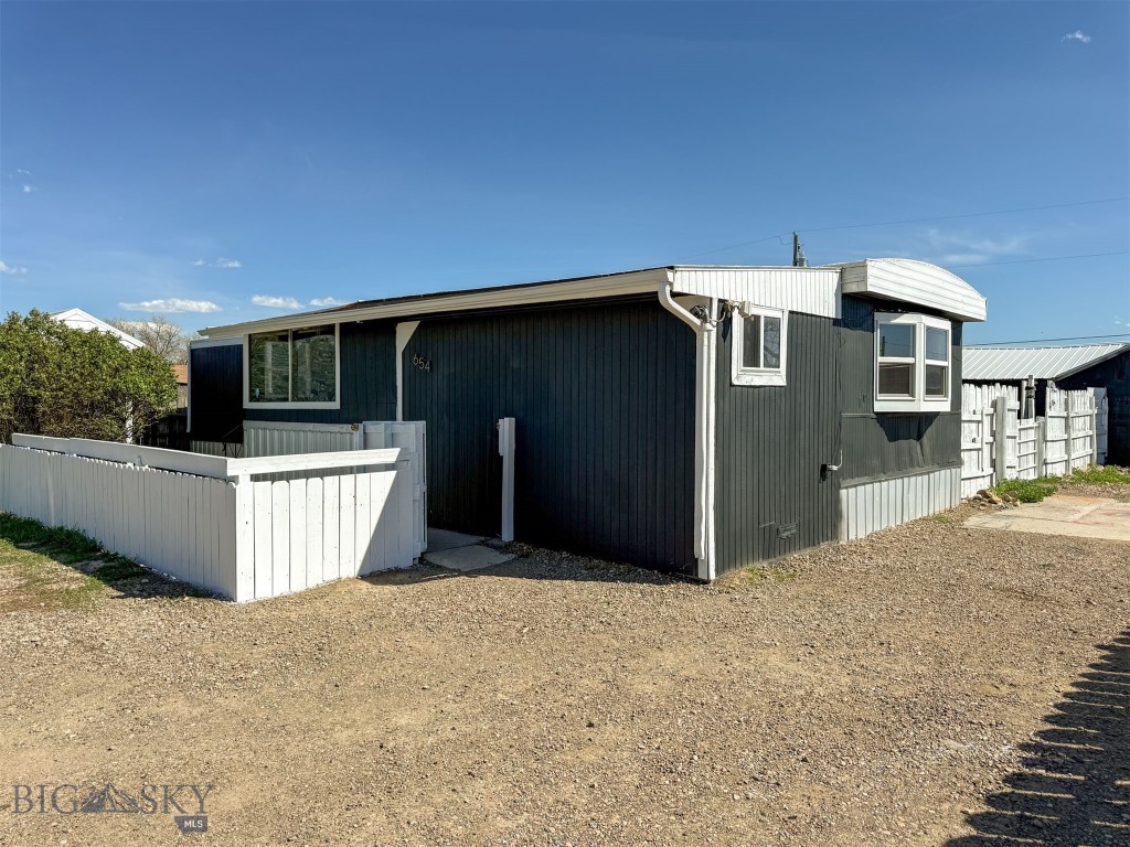 Enjoy mountain and butte views from this tastefully remodeled manufactured home on a .19 acre fenced lot with a detached shed/shop and a carport. The home has 2 true bedrooms and an addition/flex space that could serve as a bedroom, too. The stylish kitchen offers NEW stainless steel appliances to include a gas stove/oven, refrigerator and dishwasher, new and refurbished cabinets, tile-look backsplash, black sink and new hardware, plus a pull-down, lighted faucet! Flooring in the home is high-end LVP and new carpet. The full tub/shower bathroom has all-new Life-proof LVP, hardware, faucets and lighting. The front of the home has an enclosed porch and inside, a dining space, an open living room that leads to a wooden deck with rails, bedrooms and laundry hook ups. Yard is fenced in the back and most of the front. The rugged shed/shop has a brand new metal roof and new paint. Yard has several mature shrubs, including lilac bushes. Bring your horses and chickens because there is a chicken coop out back, too. The flex room has a barn wood wall and an exterior door that leads to the backyard and a new landing with rails. Exterior and interior all re-painted. Many new windows throughout the home. Water service delivers water to fill cistern which has its own building, so you don't have to haul, unless you want to! Foundation is engineered and permanent, so de-titling in process. It has been represented that home moved once. Ulm is an unincorporated city in Cascade County, new the Missouri River. Great Falls is about 8 miles away and is easily commutable. Agent-owned.