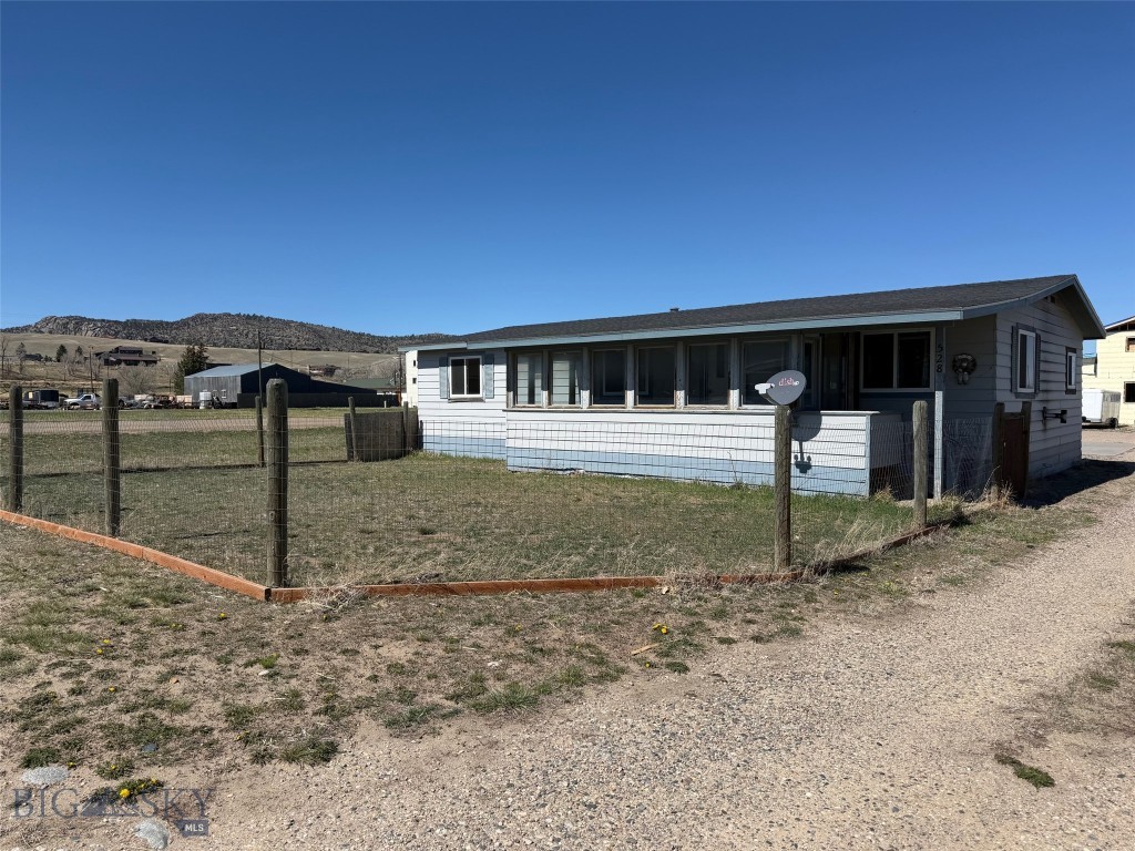 This well maintained manufactured home offers 1,056 square feet of comfortable living space with 3 bedrooms, 1 full bath, and 1 half bath. Built in 1980, the home still has its title and is not on a permanent foundation. Recent updates include a fresh coat of interior paint and new trim throughout, giving the home a clean, refreshed feel. The living area is filled with natural light and opens to a sunroom, providing additional flexible space for relaxing or entertaining. Heat is provided by a pellet stove and a propane furnace. A 500 gallon owned propane tank services the furnace, water heater, and stove. Newer windows help improve efficiency, and all appliances convey. Outside, the property is partially fenced and includes a detached two car garage with openers, plus an attached shop or storage area for tools, gear, or hobbies. All plumbing supply lines have been upgraded to copper pipe. The home is connected to Town of Ennis water and sewer, averaging approximately $65 per month while power averages just under $100/mo. Conveniently located close to schools, shopping, the hospital, golf course, and other Ennis amenities, this property offers practical living in a central location. Would make a great investments property or starter home. Buyer to verify financing options related to manufactured home with title and foundation status.