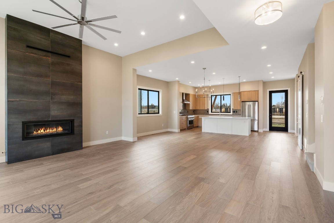 Experience the perfect blend of thoughtful design, quality craftsmanship, and modern comfort in this stunning new construction home. Backing to open space and offering a highly functional floor plan, this residence was designed to elevate everyday living. The heart of the home features an open-concept layout filled with natural light, soaring ceilings, and oversized windows. The kitchen is both beautiful and practical, showcasing quartz countertops, soft-close cabinetry, premium KitchenAid appliances, a walk-in pantry, and plenty of space for gathering. The adjoining dining and living areas create an inviting atmosphere, complete with a cozy fireplace and seamless access to the covered patio. The main level also offers exceptional flexibility with a front room that functions perfectly as a home office, guest suite, or additional bedroom, paired with a nearby three-quarter bath. Tucked away for privacy, the primary suite serves as a luxurious retreat with a spacious walk-in closet, heated tile floors, dual vanities, a freestanding soaking tub, and an impressive tiled shower with dual showerheads. Upstairs, you'll find three additional bedrooms and a full bathroom, including a generously sized bonus room that can easily serve as a fifth bedroom, media room, playroom, or secondary living space. Additional highlights include a spacious three-car garage, a well-appointed mudroom and laundry area with custom built-in storage, and high-end finishes throughout. Located in the highly sought-after Creekside community, this home offers easy access to Monforton School, The Picklr, neighborhood parks and paths, shopping, dining, downtown Bozeman, Bozeman Yellowstone International Airport, and the endless outdoor recreation.