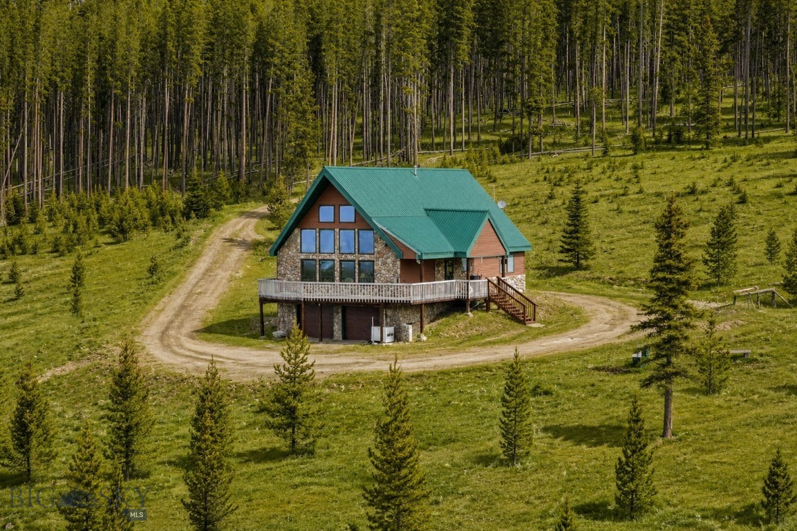 Perched above Georgetown Lake with sweeping views of the Pintler and Sapphire Mountain Ranges, 105 Damsel Lane is Montana living at its finest. This immaculate three-bedroom, three-bath home sits on 4.22 private acres where the landscape shifts with every season; beargrass, lupine and wildflowers bloom in the spring, trails and the lake beckon all summer, and snow-dusted peaks define the winter horizon.
Inside, the great room features a two-story vaulted wood ceiling and large windows that frame the lake and mountains beyond. Step onto the deck to take in the fresh Montana air along with unparalleled views of Georgetown Lake and the surrounding ranges. The open and welcoming layout includes a spacious kitchen, living and dining areas, a cozy fireplace, and a generous loft which is ideal as a home office or quiet retreat. The property is also exceptionally well equipped for year-round Montana living, featuring two 1,000-gallon underground propane tanks, a backup generator, and a spacious three-car garage with additional basement storage.
The Georgetown Lake Wildfire Risk Reduction Program through DNRC was completed on this property in October 2025, offering added peace of mind. Covenant allowances also permit an additional cottage upon approval — a welcome flexibility for guests or future expansion.
Bordering National Forest Service land, the subdivision also sits in close proximity to miles of hiking, biking, ATV, and cross-country ski trails. Georgetown Lake's boat launch and legendary fishing are just minutes away, while nearby Discovery Ski Area, Old Works Golf Course and the blue-ribbon waters of Rock Creek round out a recreation portfolio that is truly second to none.
Offered fully furnished this is a rare turnkey opportunity to own a piece of Montana's finest, where privacy, panoramic beauty, and four-season adventure converge.