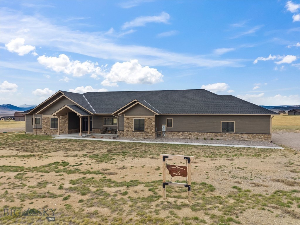 Set in the desirable Pronghorn Meadows subdivision, this beautifully crafted 2024 home offers 2,838± sq ft of thoughtfully designed living space on 1.89 acres, with breathtaking views of the Madison Range, blending comfort, style, and Montana living at its best. The heart of the home is a stunning, oversized kitchen featuring custom maple cabinetry, quartz countertops, and an expansive island with abundant storage, perfect for entertaining or everyday living. A dedicated coffee bar with its own sink adds both charm and functionality, while the large walk-in pantry keeps everything organized. The open-concept living area showcases 9’ ceilings with a dramatic 16’ vaulted ceiling, anchored by a gas fireplace with rock surround and built-in shelving with a TV niche, creating a warm focal point. Pergo wood flooring runs throughout, complemented by alder trim, doors, and Andersen windows. The spacious primary suite offers a true retreat, complete with a large walk-in closet connecting to the laundry room. The ensuite bath features a custom tiled walk-in shower, dual vanities with quartz tops, and a generous linen closet. Two guest bedrooms provide comfortable accommodations, one with a ¾ ensuite and the other served by a full hall bath. Additional highlights include a functional mudroom off the garage with built-in cubbies and storage, plus multiple closets throughout. The laundry room is generously sized and roughed-in for a sink. Step outside to a maintenance-free deck overlooking a fenced backyard with established grass and a sprinkler system. The remaining acreage is a blank canvas for the new owner to create their vision. The oversized 35x33 three-car garage with workbench area is fully finished and insulated, offering ample room for vehicles, gear, and storage. The home also includes a large unfinished basement with egress windows, ready for future expansion. Equipped with central air and forced propane heat, this home ensures year-round comfort. Located just a short drive to Ennis and within easy reach of Bozeman, you’ll enjoy convenience and access to world-class recreation, including blue-ribbon fly fishing on the Madison River, hiking, hunting, and endless outdoor adventures. This is modern Montana living with space to grow.