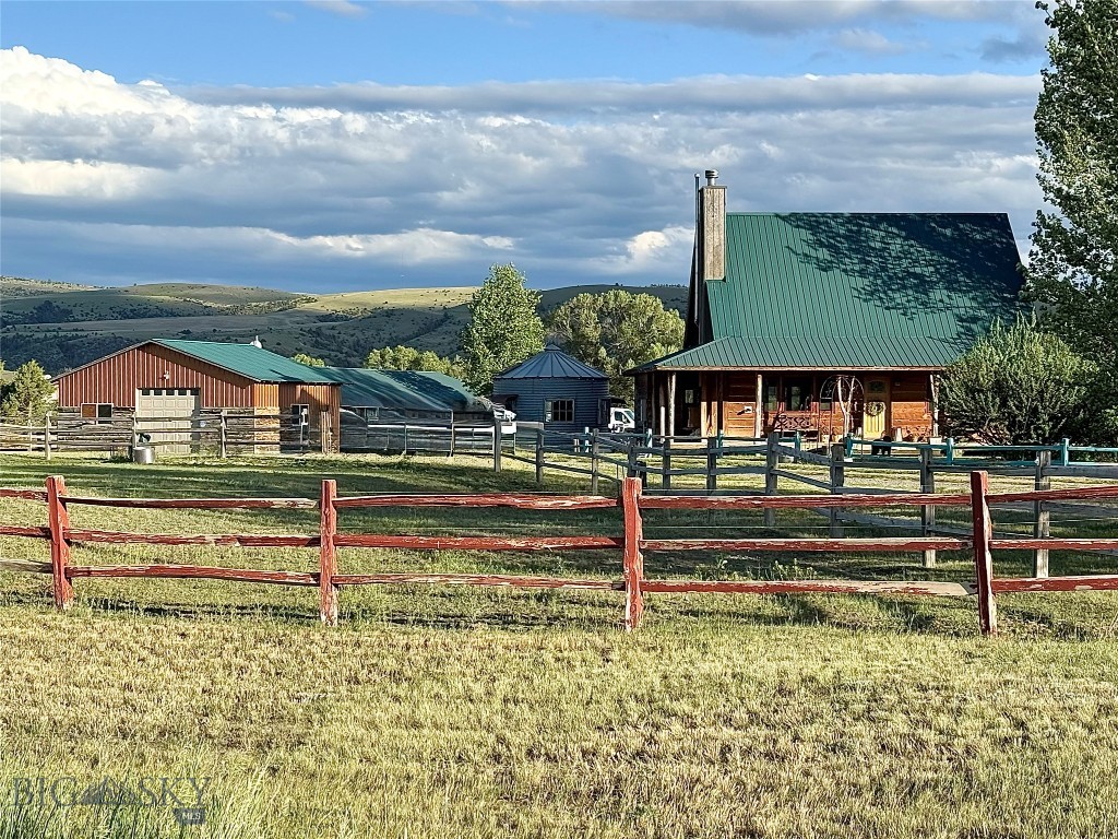 Live the Western Dream! Welcome to the perfect Montana ranchette, where rustic charm, functionality, and outdoor adventure come together on ~9 fenced acres bordering public land. Bring the horses and embrace the Montana lifestyle with this one-of-a-kind property featuring a custom-built home, guest cabin, shop/barn, and the unforgettable "Silo Saloon." Originally built as a summer home, the second owners have meticulously maintained the home and property. While a beautiful primary home, the location is ideal for the home and/or cabin to be used as a short or long-term rental. The ~1,600-square-foot custom home showcases exceptional craftsmanship & character, highlighted by live-edge exterior siding, a welcoming wrap-around porch, and stunning rustic finishes throughout. Inside, you'll find a beautiful rock fireplace, antique tin ceilings, and custom cabinetry accented with authentic Saguaro cactus ribs. The flexible floor plan offers the option of a main-level or upper-level primary bedroom, while the loft space can be converted to create a third bedroom. Some furnishings may convey. Upgrades include a pellet stove, 24w propane generator and invisible pet fence. Guests will enjoy their own private cabin complete with a kitchenette and three-quarter bath. The cabin conveys mostly furnished. Equestrian enthusiasts will appreciate the four-stall design, paddocks, and covered storage. Ride directly from the property onto the adjoining State land. The majority of the property is fenced with additional paddocks and there is a 50gpm well. The ~1,300-square-foot shop/garage/barn offers three oversized doors & a concrete floor, providing ample space for vehicles, equipment, and recreational toys. The tractor, mower, and other maintenance items may convey. Entertain family and friends in the iconic "Silo Saloon," complete with a handcrafted bar and authentic saddle bar stools—a true Montana gathering place. With the adjoining public land and proximity to the Missouri & Gallatin Rivers, this exceptional property offers endless opportunities for outdoor recreation, including abundant wildlife & game birds, hunting, fishing, rafting, horseback riding, and hiking. Conveniently located with year-round access just off the County-maintained road and near the school bus route. Only ~40 miles from Bozeman & its international airport, this extraordinary Montana retreat offers the perfect balance of privacy, recreation, and accessibility. Call your agent today!
