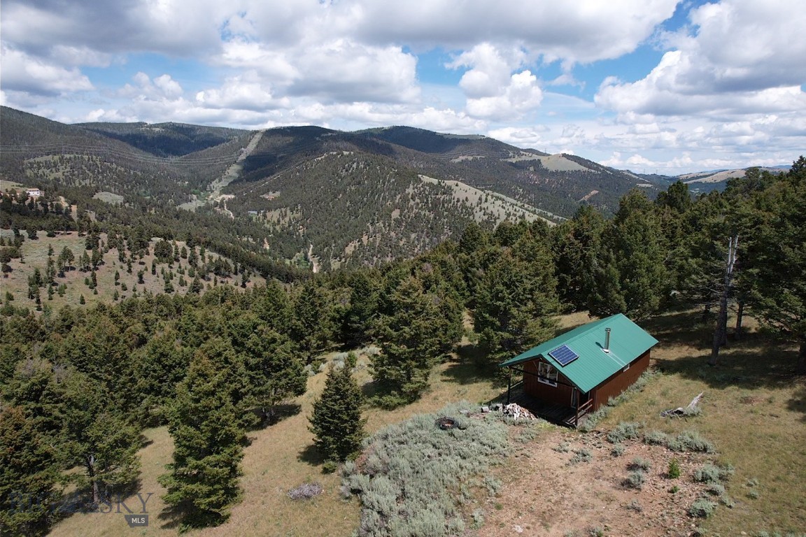 Quaint, off-grid mountain cabin located in the Boulder Mountains of Southwest Montana. The cabin features a functional and rustic interior with a maintenance free and fire-resistant exterior. Complete with a wood stove and a basic solar system for lights and necessities. The property is on just over 30 acres made up of two parcels with mixed terrain and borders public lands for hunting and recreation. The access is good but limited in the winter months. About 30 minutes to the town of Boulder, MT and 1 hour to Helena or Butte, MT. Elk, deer, and moose call this place home. Enjoy year-round recreation from this property, hunting, hiking, ATV trails and more! Come soak in the solitude of this remote property in Southwest Montana! Live your adventure!
