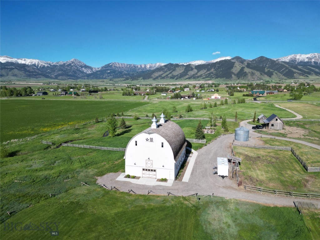 Nestled in the picturesque Springhill area of Gallatin Valley, the Star M estate is set on 33 sprawling acres and features the landmark Star M barn. The historic, hand-raised barn—originally built in 1917—has been meticulously restored and renovated from 2018 to the present. The barn is an iconic feature, blending rustic character with modern upgrades like fire suppression system and high-speed internet. The main level of the barn is outfitted with horse stalls, offering immediate equestrian use. The upper level has been used as a wedding venue in recent years, offering views of Ross Peak and the Bridger mountains, along with a seasonal creek that meanders through the beautifully kept grounds.  For those seeking small-scale agricultural or equestrian opportunities, the property includes a corral, small smokehouse, and two squeeze chutes. Additionally, the north and south 10-acre pastures remain undeveloped and leased for farming, offering agricultural use and tax benefits. The property also includes multiple residential structures, supporting flexible farm or ranch living. The reclaimed lumber main guest house, completed in 2022, features three bedrooms and two baths, while the renovated original farmhouse offers four bedrooms and two baths, along with a new furnace and septic system. A newly finished guest cabin with one bedroom and one bath provides additional space for guests or income potential as a VRBO/Airbnb rental (2024). Additional amenities include a heated and insulated 40x60 shop (built in 2021), ideal for equipment or hobby use, a renovated shed converted into office space, and an RV pad with full hookups. With all-new electrical (800-amp service), four wells and three new septic systems—two allowing for added structures—the property is well-suited for future expansion or possible subdivision. Whether you envision it as a small farm, horse property, or rural acreage close to Bozeman, Star M Barn is one of a kind. Schedule your private tour today!