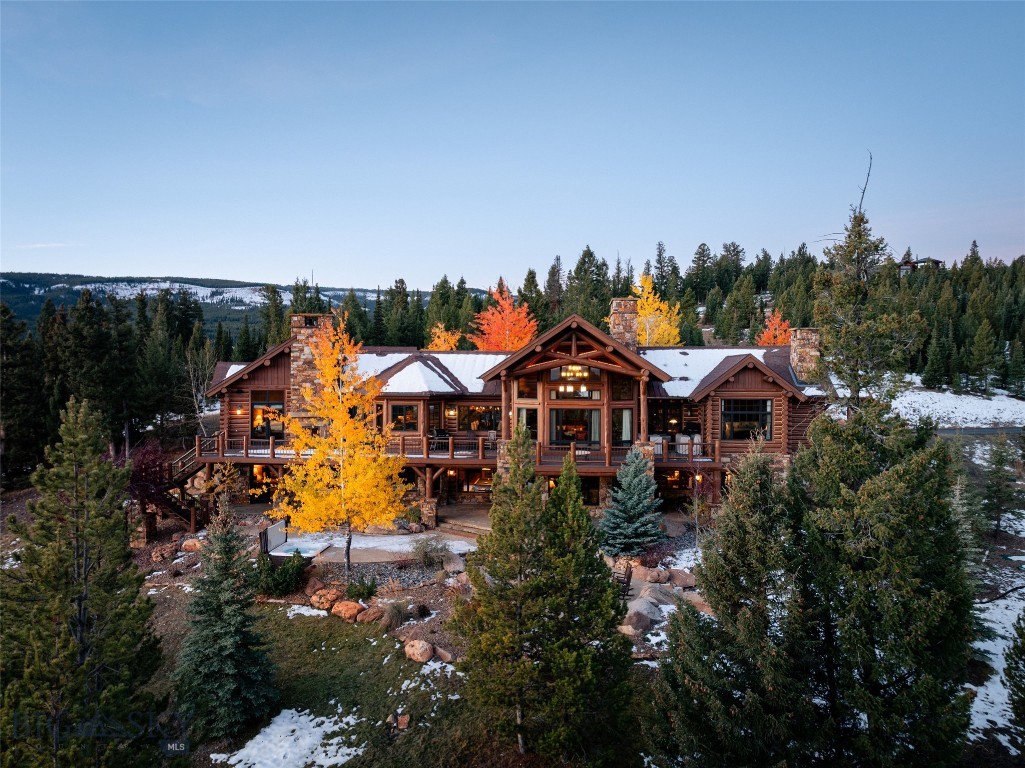 A Legacy Estate Above It All

Commanding one of the most breathtaking vantage points in Big Sky, 168 Charlie Russell is an exquisitely artisan-crafted, hand-hewn log estate—an offering reserved for those who value privacy, provenance, and permanence. Set within the gated enclave of Big EZ Estates and spanning 20 pristine acres, this is a rare opportunity to acquire a true Montana legacy home with the ability to obtain a golf or ski/social membership at Spanish Peaks Mountain Club.

At 7,434± square feet, the residence captures sweeping, cinematic views of Yellowstone National Park and the Spanish Peaks—where sunrises, moonrises, and alpenglow sunsets become part of daily life.

Designed for both grand entertaining and intimate retreat, the home features five bedrooms, five full baths, and two powder rooms, complemented by six interior fireplaces, an outdoor fireplace, a landscaped fire pit, and a new hot tub for four-season enjoyment. Four private primary suites—each with its own fireplace, outdoor access, and individual climate control—offer hotel-level comfort and exceptional privacy for owners and guests alike. A charming timber-frame bunk room with en-suite bath adds warmth and character for family gatherings.

The main level unfolds with soaring ceilings, a dramatic floor-to-ceiling stone fireplace, expansive living and dining spaces, and a gourmet kitchen outfitted with premium appliances and generous prep areas—ideal for entertaining at scale. An executive office with private deck access sits just off the great room and primary suite, blending productivity with inspiration. The primary suite itself is a sanctuary, featuring a fireplace, spa-like bath, walk-in closet, and private deck overlooking the peaks.

The lower level is dedicated to recreation and relaxation, offering a spacious family room, wet bar, pool table, additional fireplace, and seamless access to outdoor living—where the hot tub and fire pit invite evenings under Montana’s vast sky. A wrap-around deck, multiple patios, and tranquil mountain vistas complete the experience.

With 20 acres of usable land, room for future enhancements, remarkable privacy, and immediate proximity to the world-class amenities of Big Sky, 168 Charlie Russell embodies the very essence of the Big EZ lifestyle. Timeless, irreplaceable, and uncompromising—this is not simply a residence, but a legacy to be stewarded for generations.