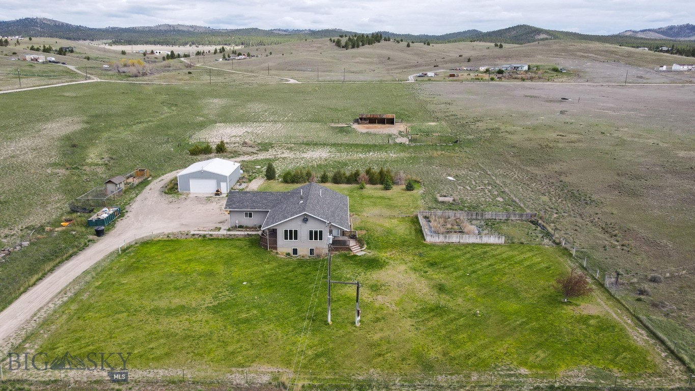 Discover the perfect blend of country living, equestrian functionality, and modern comfort on this exceptional horse property with no covenants and endless opportunities to enjoy the Montana lifestyle. This spacious 2,656 sq ft home features a desirable layout with a main-level primary suite and two additional guest bedrooms on the main floor. The open kitchen flows into a spacious living room where oversized windows showcase breathtaking views and flood the home with natural light. Home has central A/C throughout for year-round comfort. The fully finished basement offers an expansive family room, along with two bonus rooms and a bathroom that provides flexible space for an office, gym, hobby room, or additional sleeping areas. Outdoor living is equally impressive with covered front and back porches designed to take in the incredible scenery and peaceful surroundings. The large fenced yard includes automatic underground sprinklers and raised garden beds and the mature landscaping creates a beautiful and functional outdoor space. Horse enthusiasts will appreciate the well-equipped setup featuring covered corrals with 3 stalls, a dry lot, automatic waterer, grazing pastures, and a 75x150 outdoor riding arena. Ride directly from your property or down the road and enjoy nearby BLM access for endless horseback riding opportunities. A heated 30x48 shop provides ample space for equipment, toys, projects, or storage, while the chicken coop with both heat and A/C adds even more versatility to this thoughtfully designed property. Located just 10 minutes from Hauser Lake, this property offers the ideal combination of privacy, recreation, and convenience, with room to truly enjoy the outdoors, entertain guests, and embrace the rural lifestyle. Make your showing appointment today before it's sold!
