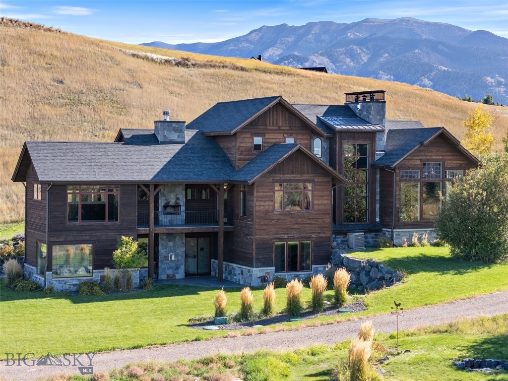 Experience the perfect blend of luxury, privacy, and Montana beauty in this custom-built 6,359 sq ft home nestled on over 4 pristine acres just minutes from downtown Bozeman and Yellowstone International Airport. With 5 spacious bedrooms and 4.5 bathrooms, this home was designed with comfort and flexibility in mind. The main-level primary suite offers a true retreat, featuring its own private laundry, a spa-inspired bathroom, and exclusive access to a private outdoor deck. Thoughtfully designed outdoor living spaces surround the home, including a cozy lounge area with a wood-burning fireplace, perfect for year-round entertaining. Upstairs, you'll find two large en-suite bedrooms and two full bathrooms, while the expansive walkout basement boasts an impressive bunk room with four built-in full-size beds, two additional bedrooms, a full bathroom, an office, and a family room with built-in surround sound. The lower level also opens to multiple outdoor living areas and includes plumbing for an additional bathroom, plus space already prepped for a sauna and cold plunge area or whatever your heart desires to create! Beyond the main residence, the property features a stunning barn structure ready for your custom interior build-out. With 1,215 sq ft of garage/warehouse space and 2,337 sq ft of office or habitable area (totaling 3,552 sq ft), the potential for this space is endless. Green thumbs will love the fully irrigated garden area, complete with a greenhouse, powered garden shed with water, and multiple raised garden beds—ready to support your growing goals. Wildlife frequently visits this peaceful property, and with recreation just outside your door, you’ll enjoy all the natural beauty Montana has to offer without sacrificing convenience—just 7 minutes to downtown Bozeman and 10 minutes to the airport.