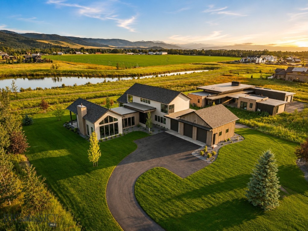 Designed by 45 Architecture & Interiors and curated by Speer Designs, this exceptional custom residence is a masterful blend of timeless architecture, elevated craftsmanship, and refined Montana living. Nestled within the exclusive Home 40 on Bozeman's coveted south side, the home sits on over an acre with sweeping mountain, pond, and open space views, offering an extraordinary sense of privacy just minutes from downtown Bozeman, Hyalite Canyon, and the world-class skiing and recreation of Big Sky Resort. A grand foyer welcomes you with a Hudson Valley Ray chandelier, European white oak flooring, and reclaimed Corral Board accents, setting the tone for the interiors beyond. The main level is anchored by an expansive great room with soaring vaulted ceilings, walls of glass, and a dramatic floor-to-ceiling fireplace. The chef's kitchen pairs custom Red Oak cabinetry with elegant grey granite countertops, a custom range hood, Thermador stainless steel appliances, designer Huan pendants, and a spacious walk-in pantry with prep space, floating shelving, and a secondary sink. A beautifully appointed wet bar with custom Peppercorn oak cabinetry, MSI Muntaz Majal quartz, and a NativeStone sink creates an inviting space for entertaining. The main-level primary suite is a true sanctuary, offering a spa-inspired bath with a freestanding soaking tub, oversized walk-in shower, custom cabinetry, and serene Scandinavian-inspired finishes. A private main-floor office offers a quiet retreat, while the oversized laundry room features custom cabinetry, quartz countertops, and abundant storage. Just beyond, the expansive mudroom is complete with custom lockers and built-in organization, creating a seamless transition from the three-car garage. Upstairs, two generous guest suites and a spacious recreation room provide exceptional flexibility. Expansive covered patios capture panoramic views and Montana sunsets, while residents of Home 40 enjoy exclusive access to a private clubhouse, fitness center, resort-style pool, scenic ponds, and miles of trails. Combining exceptional architecture, designer finishes, and one of Bozeman's premier south-side locations, this residence represents luxury living at its finest.