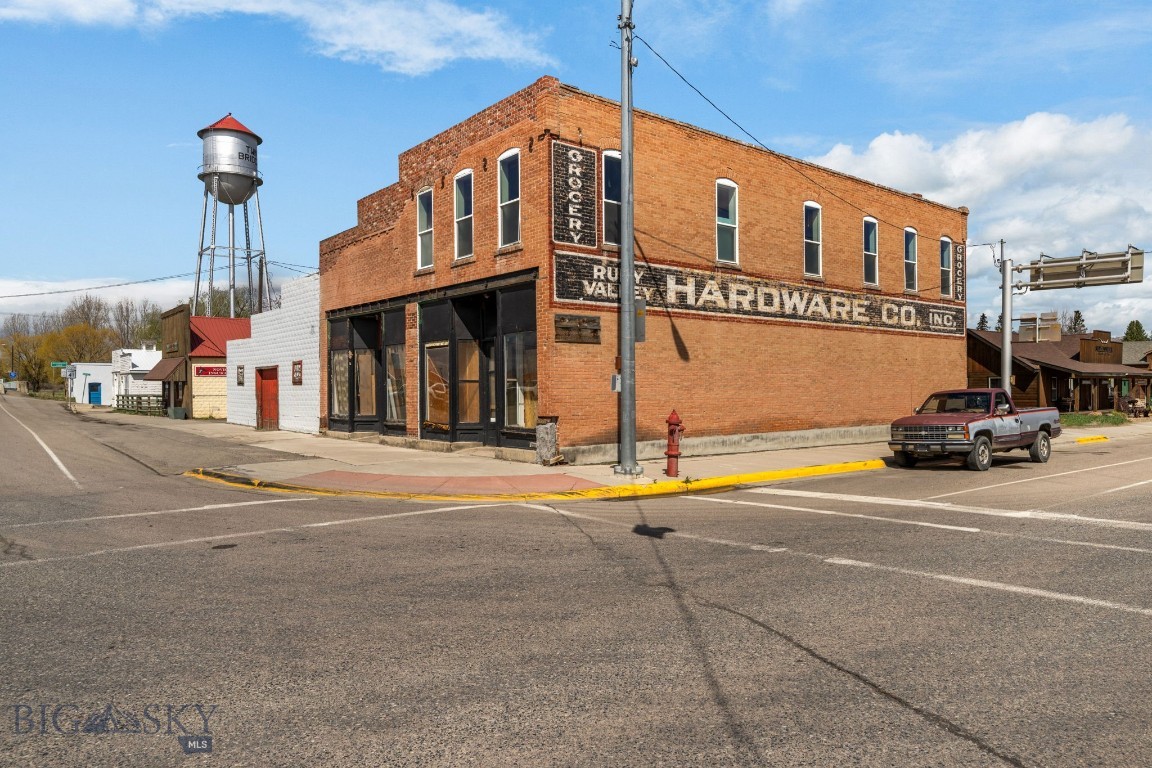 In the heart of Twin Bridges, where the Beaverhead, Big Hole, and Ruby Rivers merge to form the Jefferson, sits one of the town's most versatile commercial buildings. The original 1895 red brick storefront anchors the street side, backed by massive warehouse space built with old-school post-and-beam framing that opens up room you won't find anywhere else in town. Two ground-level storefronts give you street presence for retail, office, or services, while the warehouse behind them handles everything from equipment storage to fabrication to events. Upstairs, a full apartment with four bedrooms and two baths provides built-in income or a place to live above your business. Twin Bridges sits at the crossroads of world-class fly-fishing rivers, surrounded by the Tobacco Root and Highland Mountains, with a growing outdoor recreation economy. City water, city sewer, gas heat. A building this size in a town this well-positioned doesn't come along often. Don't wait! Commercial Listing: 411324. Residential Listing: 411508.