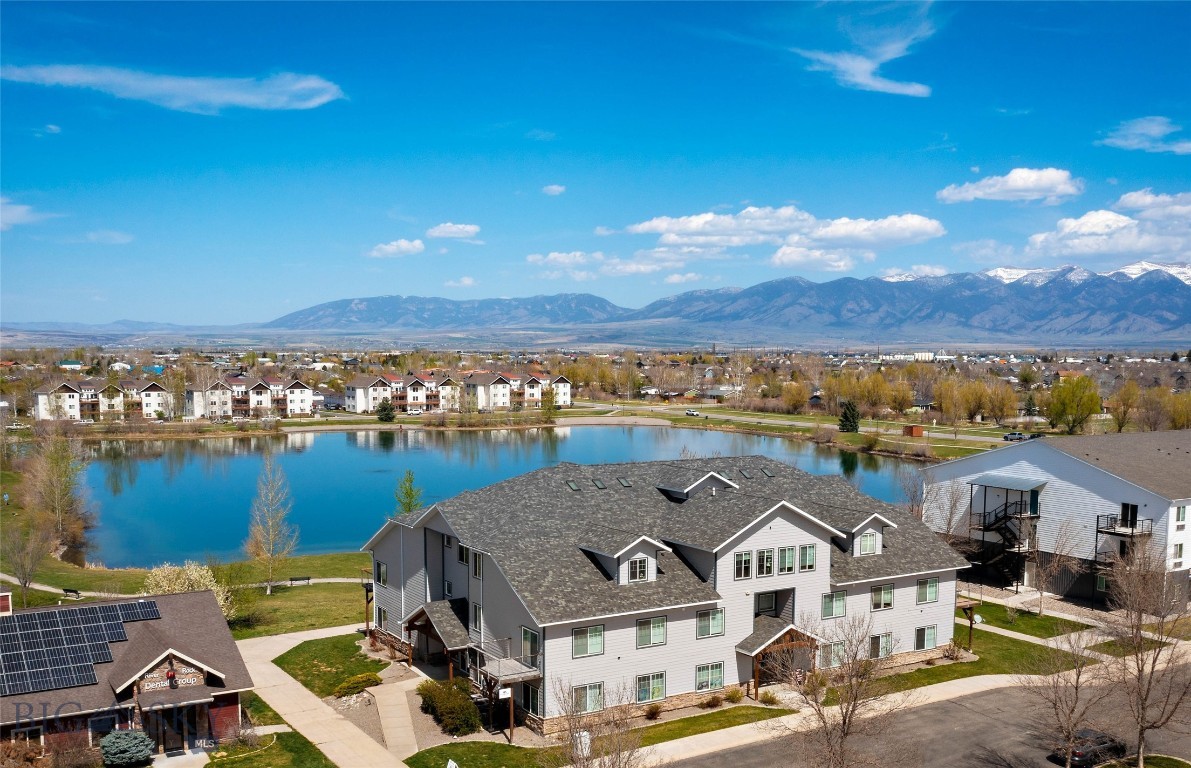 Position Your Business & Your Lifestyle in a Peaceful Waterfront Setting with Mountain Views! 301B Offers a Unique Opportunity for a Small Business Owner, Investor or Professional Seeking an Affordable & Inviting Commercial/Live-Work Space in Belgrade’s River Rock Community.
This Beautifully Updated Top-Floor Unit Features Approximately 760 Square Feet, an Efficient Open Layout, One Private Room w/Large Alcove, Full Bath, In-Unit Laundry, Forced Air Heat, Central Air & a Private Balcony Overlooking River Rock Pond & the Bridger Mountain Range. with New Flooring, Fresh Interior Paint, Added Cabinetry & Abundant Natural Light, the Space Feels Clean, Comfortable & Welcoming.
The Layout & Setting May Lend Itself Well to a Variety Of Low-Impact Professional Uses Such as Massage Therapy, Bookkeeping, Consulting, Counseling, Wellness Services, Office Space or a Quiet Studio-Style Business, Subject to Approvals. The Peaceful Pond Views & Mountain Backdrop Create a Calming Environment for Both Clients & Daily Work.
Access is Convenient with a Commercial-Sized Elevator Serving the Third Floor, Along with Ample Open Parking for Clients, Guests & Occupants. Significant Exterior Improvements, Including New Siding & Roof, Add to the Overall Appeal & Long-Term Value of the Property.
Professionally Managed HOA Dues Help Simplify Ownership by Covering Water, Sewer, Utilities, Garbage, Lawn Care, Snow Removal & Master Insurance.
Whether You are Looking for a Professional Office, a Quiet Wellness Space, a Small Business Location or an Investment Opportunity, This Move-In-Ready Waterfront Condo Offers Flexibility, Convenience, Views & an Affordable Entry Point Into Commercial Ownership.