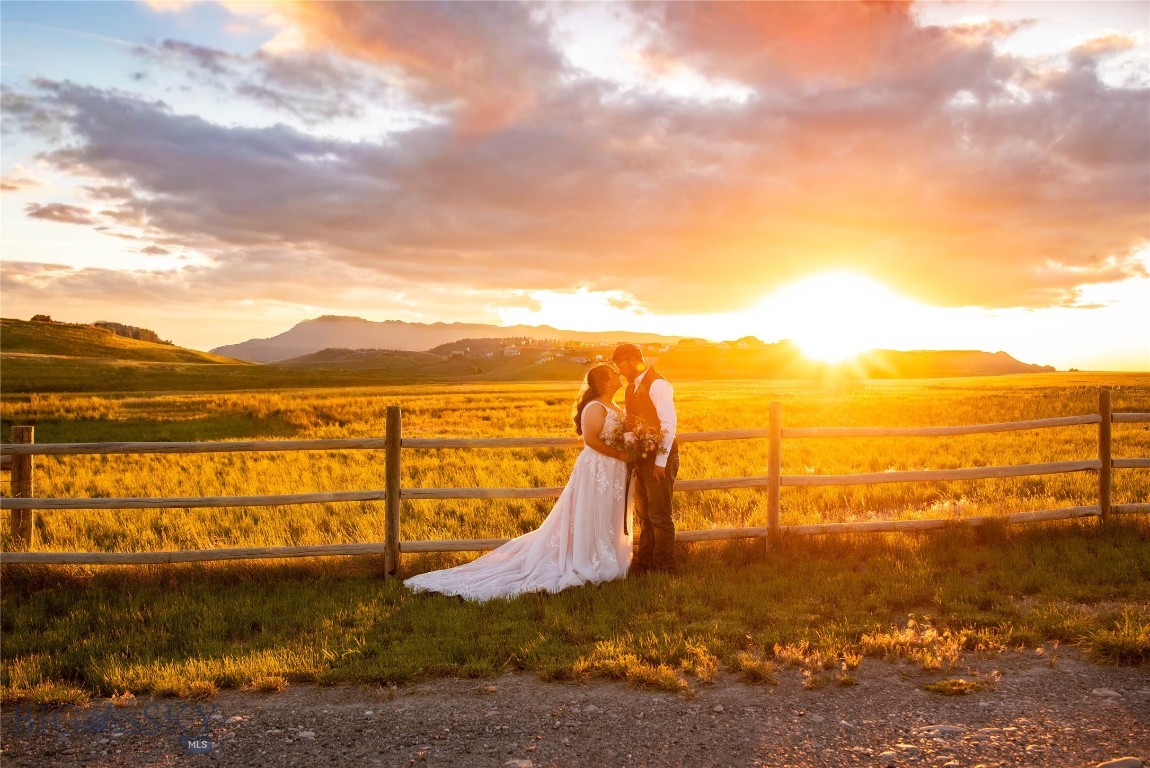 Experience the perfect blend of luxury living, income potential, and self-sustainability on this exceptional 31.73-acre farm, and established event venue. This unique property is currently operating as a successful wedding venue, creating an incredible opportunity for immediate income.

The beautifully designed 3,424 sq ft residence features 4 bedrooms (including one non-conforming) and 3.5 bathrooms, along with a spacious 2-car garage and no active HOA. The open-concept great room with vaulted ceilings provides an inviting space for entertaining, while expansive windows capture breathtaking views and abundant southern exposure. Enjoy peaceful surroundings from the covered wrap around deck, perfect for relaxing or hosting gatherings.

Purpose-built for events, the property includes a dedicated wedding barn, complete with a kitchen and bathrooms, ideal for accommodating guests. Additional guest accommodations include a charming groom’s cabin and bridal suite ADU featuring a kitchenette, living area, loft bedroom, and bathroom.

The farm and ranch infrastructure is equally impressive, featuring a 50’ x 100’ shop with a concrete floor, wood stove, oil stove, and electric heat, along with a small animal barn, chicken coop, and corrals along with an automatic water system for livestock. A wheel line irrigation system, supported by a dedicated irrigation well (currently shared with one neighboring property), typically produces approximately 10 ton of hay annually, supporting livestock and contributing to the property's self-sustaining appeal. 

Whether you’re looking to continue a thriving wedding venue business, expand an agricultural operation, or enjoy a private retreat with income-producing capabilities, this remarkable property delivers unmatched versatility, beauty, and opportunity.