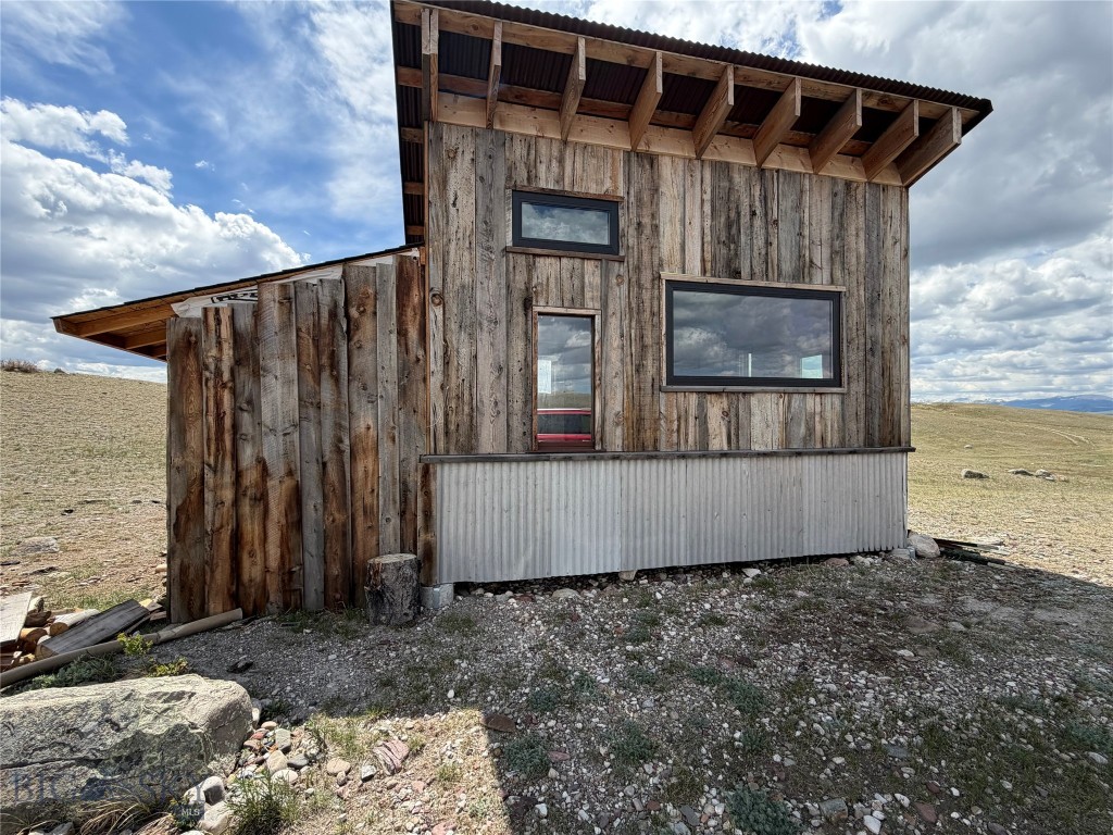 Find a spectacular combination of recreational and/or full-time living in a stunning setting with Rocky Mountain Front and Willow Creek Reservoir views. You have a head-start on this 5+ acre parcel with a darling cabin, complete with woodstove and living space, plus a fenced and a partially-completed loafing shed. Bring your chickens, because there is cover for them, plus other livestock appear to be allowed, too. Build up and take in views of Willow Creek Reservoir which is sooo close to this property. Terrain is varied, but mostly flat. Desirable moss rock is scattered on the property. Augusta is a is a small rural town and is just minutes away. Hunting, hiking and fishing are prolific in the area. Covenants are not enforced and there is no HOA. No septic. No well; current owner hauled water because wells can be deep. Roads are year-round, but not heavily groomed.